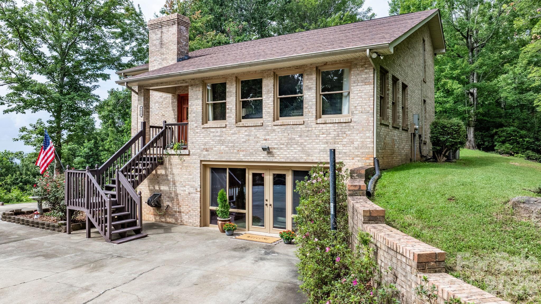 Discover this stunning 4BR/3.5BA mountain retreat on nearly 15 acres in Lenoir, NC, with breathtaking long-range views from inside and the expansive wraparound deck. The main level offers a living room with a wall of windows and a cozy stone wood-burning fireplace, plus a spacious family room great for movie nights or game days. The primary suite is also on the main level with direct deck access—allowing you to take in the scenery. Upstairs features 3 additional bedrooms and a full bath. The walk-out basement includes a game room, music room, gym area, second fireplace, and another full bath. Outdoors, enjoy level yard space with a fire pit and a shed ready to become your workshop or art studio. Quiet and secluded, yet just a short drive to downtown Lenoir, Blowing Rock, and scenic hiking trails, this home is great for year-round living or a vacation escape. Schedule your showing today—properties like this are rare!