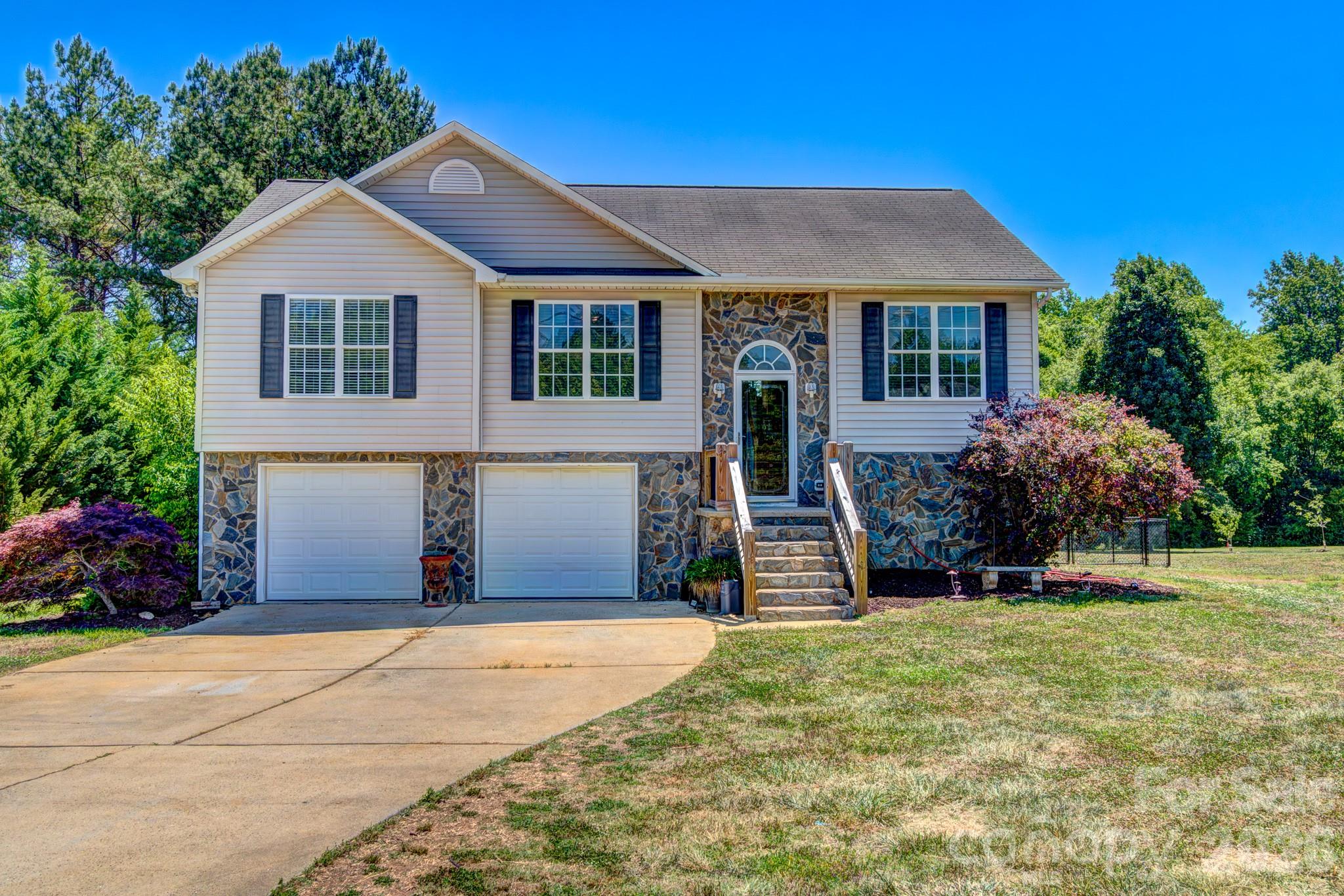 This spacious 4-bedroom, 2-bathroom home is located on 0.9 acres in Terrace Estates. The layout features an open area that combines the living room, dining area, and kitchen. The foyer entry provides open access to the upper level and leads to the lower area. The lower level is partially finished and includes the laundry area and the fourth bedroom. Additionally, the plumbing is roughed in for a potential third bathroom, though it is not yet completed. The 2-car garage is also situated on the lower level.