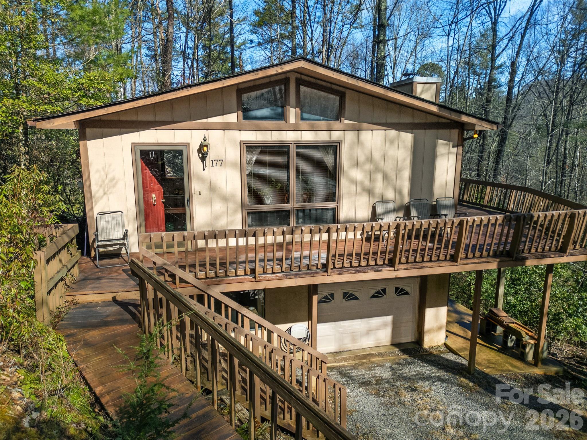 Nestled on 2.3 private wooded acres in the highly sought-after gated community of Connestee Falls, this inviting 2-bedroom 3-bath home offers a peaceful mountain retreat with a truly enchanting treehouse-like feel. Surrounded by mature hardwoods and lush greenery, the house provides a rare sense of privacy and connection to nature, with the sights and sounds of the forest providing a calming backdrop year-round.

The open-concept main living area is warm and welcoming, with vaulted ceilings and expansive windows that flood the space with natural light and frame beautiful woodland views from nearly every angle. Whether relaxing by day or entertaining in the evenings, the layout is both comfortable and functional, allowing the outdoors to feel like a natural extension of the home.

The two spacious bedrooms are thoughtfully designed for privacy and comfort, while three full bathrooms offer convenience for homeowners and guests alike. A large bonus room adds exceptional flexibility and is ideal for a guest suite, home office, hobby or craft room, fitness space, or artist’s studio. This versatile area allows the home to adapt easily to your lifestyle needs, whether for full-time living or a mountain escape.

Step outside onto the private deck and immerse yourself in the peaceful wooded setting, perfect for enjoying morning coffee, listening to birdsong, or unwinding after a day of exploring all that Connestee Falls has to offer. The expansive 2.3-acre lot enhances a sense of seclusion while remaining part of a vibrant, amenity-rich community.

Connestee Falls is known for its stunning natural beauty and exceptional amenities, including miles of hiking trails, waterfalls, lakes, an 18-hole golf course, clubhouse, swimming, tennis, pickleball, and year-round social activities. Located just minutes from downtown Brevard, you will enjoy easy access to local shops, dining, music, and outdoor adventures, including Pisgah National Forest and Dupont State Recreational Forest.

Some furnishings are negotiable, offering an excellent opportunity for a smooth and seamless transition. Whether you are searching for a full-time residence, second home, or peaceful mountain getaway, this nature-infused property delivers privacy, charm, and the relaxed mountain lifestyle Connestee Falls is known for. Do not miss the chance to make this tranquil retreat your own.