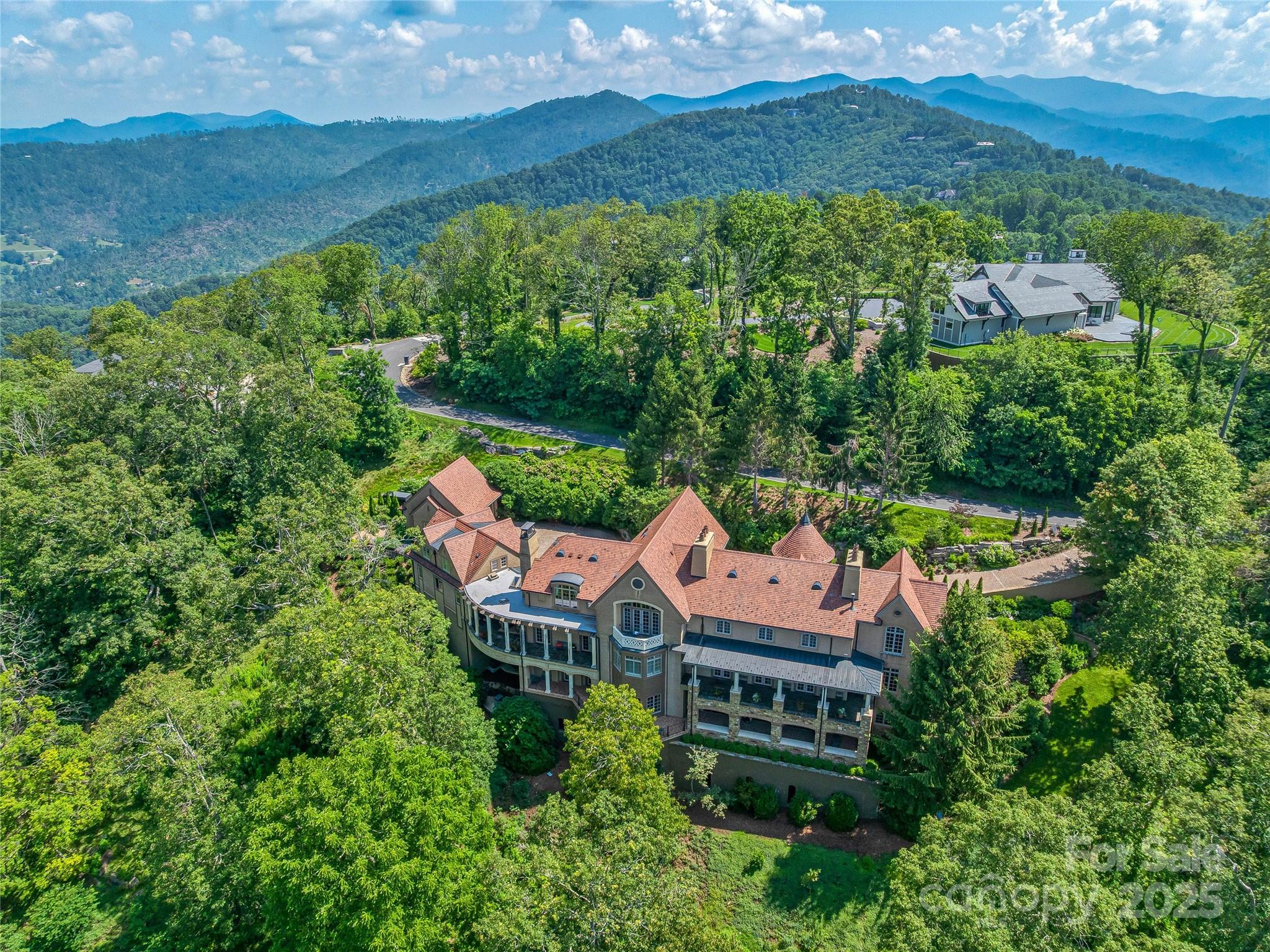 This luxe estate will be sold at Luxury AUCTION Without Reserve on July 16, 2026! List price for REFERENCE ONLY. Offered in co-op. with Platinum Luxury Auctions. Inquire for details.

This luxurious European-inspired home has breathtaking views of the Blue Ridge Mountains and is ideally located just miles from downtown Asheville. Meticulous craftsmanship and opulent finishes are showcased throughout, including Italian limestone fireplaces, custom ironwork, and a striking Verdi Fire granite kitchen island. Elegant flooring of quarter-sawn oak, marble, and Jerusalem limestone enhances the home's sophisticated ambiance.
Designed for both comfort and grandeur, the home offers seamless spaces for private relaxation and lavish entertaining. The primary suite features a private balcony with panoramic mountain views, while the en-suite bathroom exudes elegance with marble floors and intricate medallion accents. A private grotto with a poured gunite hot tub and cascading waterfall creates a serene, spa-like retreat. Wine connoisseurs will appreciate the climate-controlled wine cellar, and film lovers can indulge in the custom home theater with luxurious leather seating.
