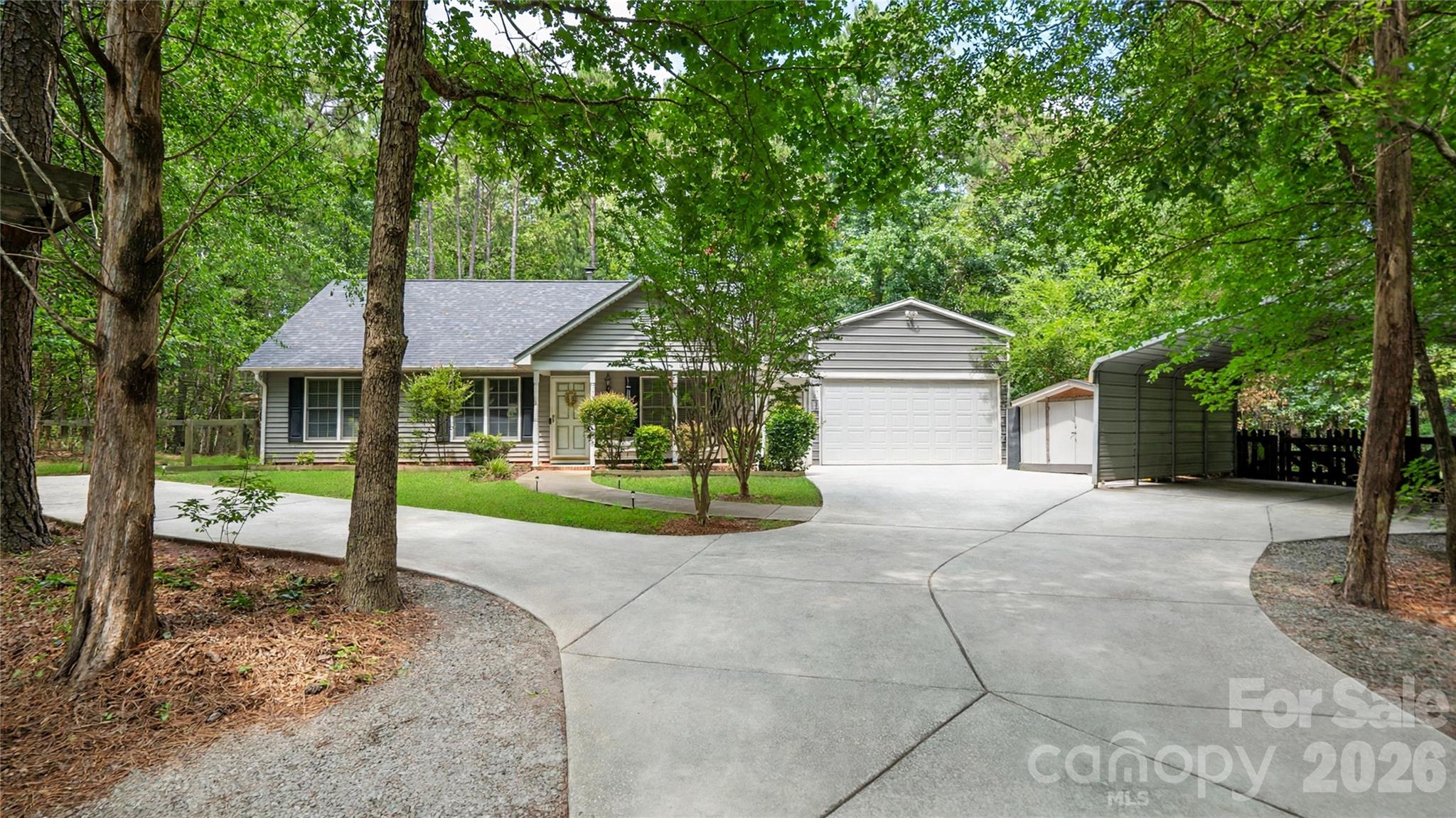 Welcome to this three-bedroom ranch home on almost 1 acre of land .92 with NO HOA!!! This home offers a cozy family room with a wood burning fireplace and spacious kitchen with granite counter tops that opens to a lovely dining area with French doors, leading to a covered patio, privacy fenced back yard with a jacuzzi.  Inside you will find that the bedrooms have ample amount of space with plenty of natural light. Gleaming wood laminate flooring throughout the home and fresh paint.  This home offers a heated and cooled 2 car garage with a car lift, along with a 2-car carport and 2 storage sheds. Beautiful neighborhood with lots of trees and privacy.  10 minutes to DOWNTOWN WAXHAW!!! County taxes only, no city taxes. Septic and well water.