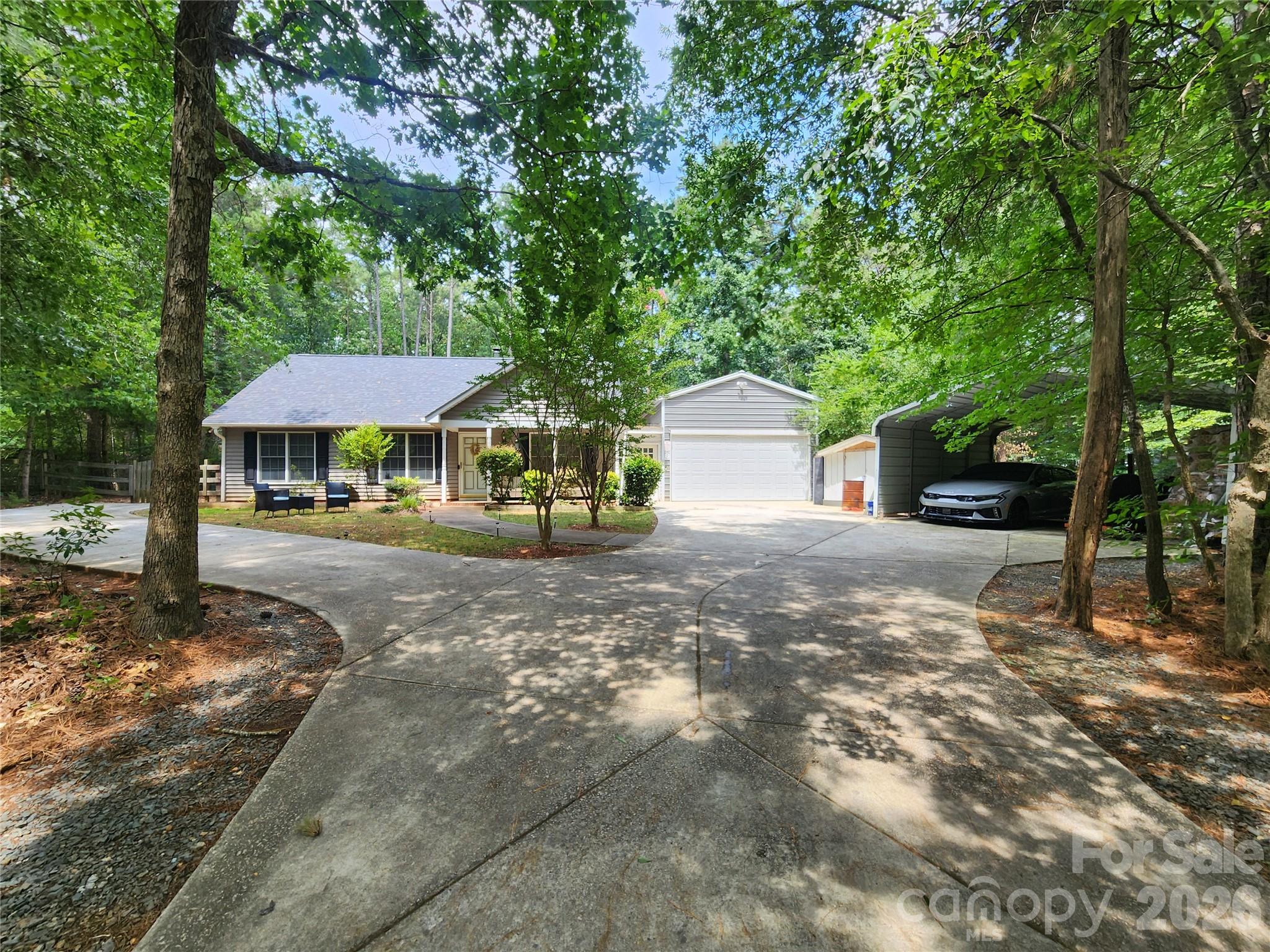 Welcome to this three-bedroom ranch home on almost 1 acre of land .92 with NO HOA!!! This home offers a cozy family room with a wood burning fireplace and spacious kitchen with granite counter tops that opens to a lovely dining area with French doors, leading to a covered patio, privacy fenced back yard with a jacuzzi.  Inside you will find that the bedrooms have ample amount of space with plenty of natural light. Gleaming wood laminate flooring throughout the home and fresh paint.  This home offers a heated and cooled 2 car garage with a car lift, along with a 2-car carport and 2 storage sheds. Beautiful neighborhood with lots of trees and privacy.  10 minutes to DOWNTOWN WAXHAW!!! County taxes only, not city taxes. Septic and well water.