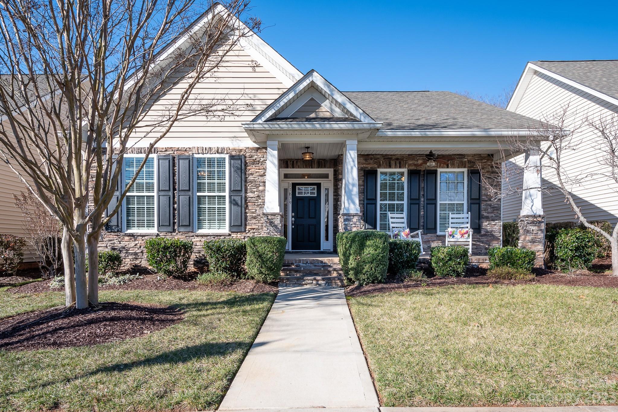 Enjoy this generously enhanced and spacious Hunter house plan in premier 55+ community.  Beautiful stone front home with rocking chair front porch enters into inviting, extended foyer and large, open great room, tray ceiling with wainscoting. The location is fabulous!!  Live like you are on vacation all year just steps away to Clubhouse, pool and activities or enjoy your very private treed yard off of enclosed sunroom or back screened porch.  Home has brand new Luxury Vinyl Plank flooring and interior has been recently refreshed and painted. Lighting is upgraded, granite countertops throughout, beautiful cream colored cabinets, stainless appliances and laundry room with handy laundry tub.  Washer, dryer and kitchen refrigerator are included in the sale however the Safe and Refrigerator in garage do not convey.  This is truly a Beauty!
HOA includes lawn maintenance, full time lifestyle director, clubhouse, resort style pool, Pickleball, tennis, wood shop, many clubs and so much more.