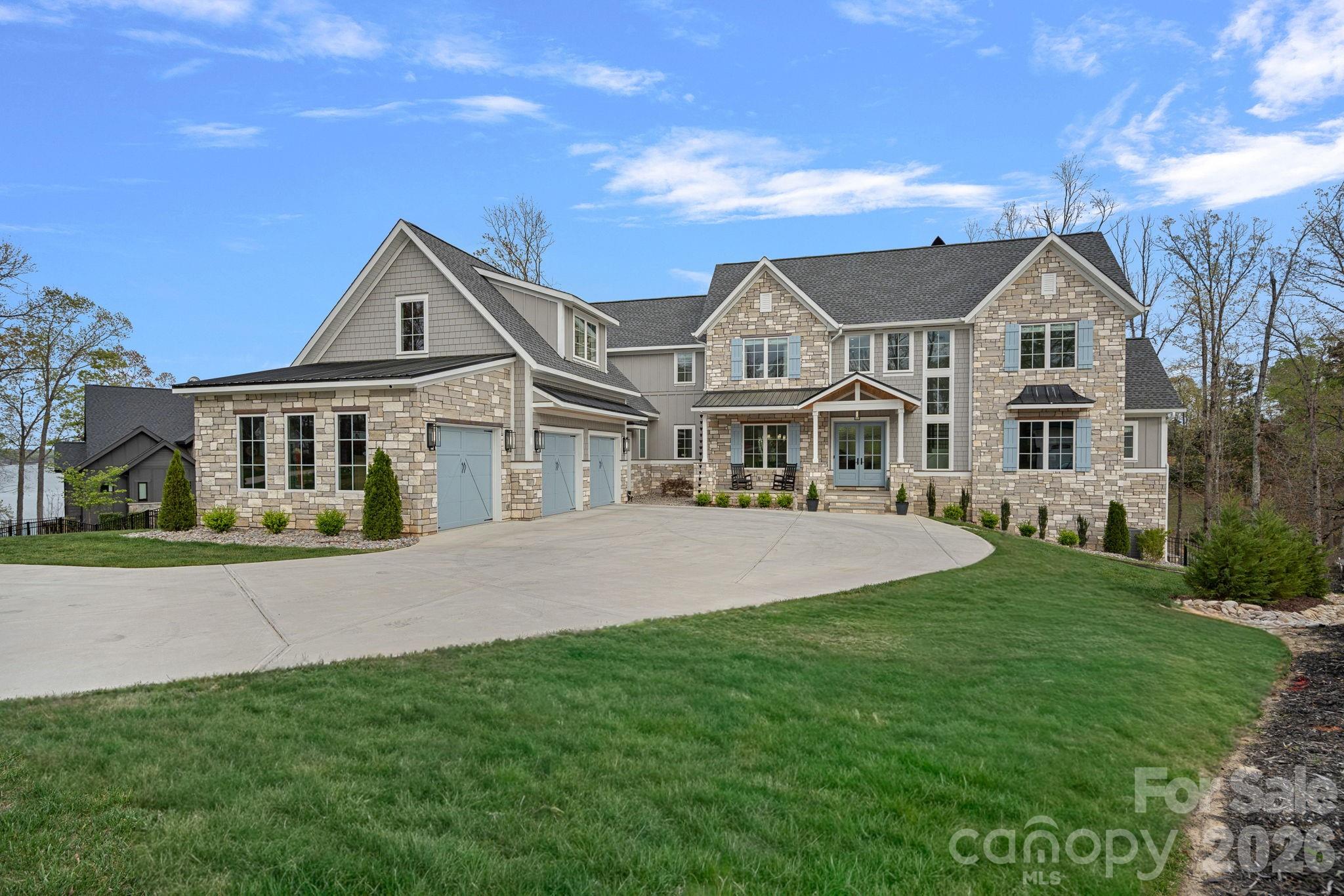 Luxury Waterfront Living on Lake Wylie

Experience the pinnacle of lakefront luxury with this 2024 custom-built estate set along the pristine shores of Lake Wylie. Privately positioned on 2.92 acres of deep-water frontage along a dockable homesite, this 4-bedroom, 4.5-bathroom residence captures breathtaking panoramic views and sunsets you'll never tire of — delivering a rare combination of seclusion, sophistication, and refined waterfront living.

Step inside and discover an interior where elevated elegance meets thoughtful functionality. Soaring ceilings, walls of expansive windows, and rich pecan engineered hardwoods set the tone throughout the main living spaces, while the open-concept layout draws your eye straight to the water. At the heart of the home, a chef's kitchen is outfitted with a world-class suite of appliances — a Wolf range and microwave, Sub-Zero refrigerator, freezer, and wine storage, along with a KitchenAid dishwasher and ice maker. Quartzite countertops add natural luxury with beauty and durability to match. A beautifully appointed scullery rounds out the culinary experience, ideal for effortless prep, discreet storage, and seamless large-scale entertaining.

Artisan craftsmanship is evident throughout, from the dramatic Isokern fireplaces and custom Cooperstone Natural Stone finishes to the striking Wichita White interior feature wall. The curated exterior blends charcoal, Castle Grey, and Austin White for a timeless architectural presence that is as commanding from the water as it is from the street.

The primary suite is a private retreat with serene lake views and a spa-inspired bath highlighted by a designer Miseno tub filler. Visual Comfort ceiling fans and a fully integrated Sonos sound system — indoors and out — create an effortless atmosphere of comfort and modern sophistication throughout the home.

A thoughtfully included elevator shaft speaks to the home's forward-thinking design, offering the option for future installation and ensuring effortless accessibility across every level for years to come.

Outdoor living is equally impressive. A covered patio with low-maintenance composite decking flows to a fully equipped outdoor kitchen featuring premium Coyote Outdoor Living appliances, purpose-built for year-round lakeside entertaining. With nearly three acres of privacy and direct access to deep water, the lifestyle possibilities are wide open — whether launching a boat, paddleboarding at sunrise, or building your own private dock.
Below it all, a full walk-out basement — framed and rough plumbed, with the hard work already done — is ready for your vision. Whether that means a home theater, private fitness studio, or expansive additional living quarters, the foundation for something exceptional is already in place.

One of Lake Wylie's most coveted waterfront offerings — where exceptional design, natural beauty, and an unmatched lifestyle all come together in one remarkable property.