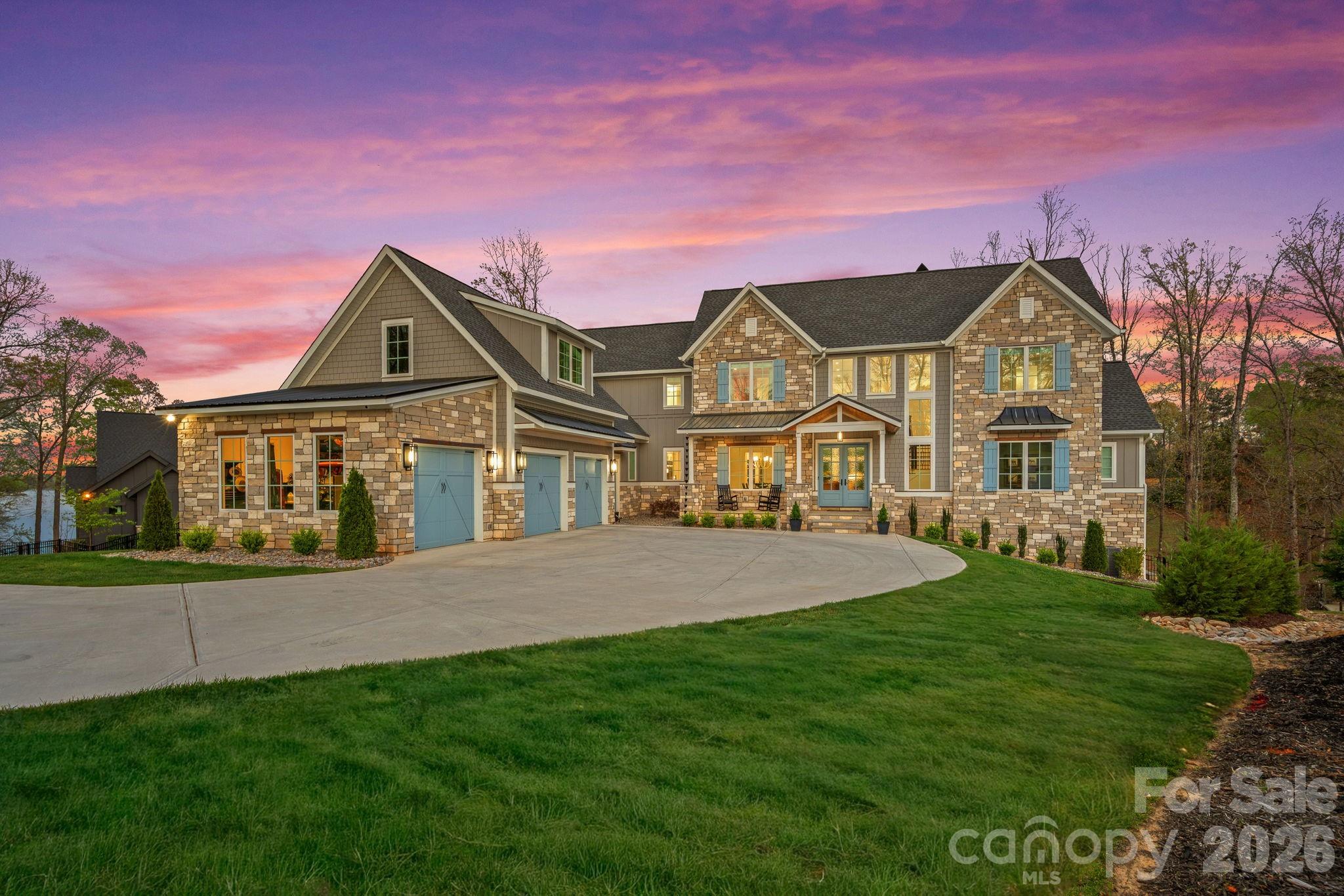 Luxury Waterfront Living on Lake Wylie

Experience the pinnacle of lakefront luxury with this 2024 custom-built estate set along the pristine shores of Lake Wylie. Privately positioned on 2.92 acres of deep-water frontage along a dockable homesite, this 4-bedroom, 4.5-bathroom residence captures breathtaking panoramic views and sunsets you'll never tire of — delivering a rare combination of seclusion, sophistication, and refined waterfront living.

Step inside and discover an interior where elevated elegance meets thoughtful functionality. Soaring ceilings, walls of expansive windows, and rich pecan engineered hardwoods set the tone throughout the main living spaces, while the open-concept layout draws your eye straight to the water. At the heart of the home, a chef's kitchen is outfitted with a world-class suite of appliances — a Wolf range and microwave, Sub-Zero refrigerator, freezer, and wine storage, along with a KitchenAid dishwasher and ice maker. Quartzite countertops add natural luxury with beauty and durability to match. A beautifully appointed scullery rounds out the culinary experience, ideal for effortless prep, discreet storage, and seamless large-scale entertaining.

Artisan craftsmanship is evident throughout, from the dramatic Isokern fireplaces and custom Cooperstone Natural Stone finishes to the striking Wichita White interior feature wall. The curated exterior blends charcoal, Castle Grey, and Austin White for a timeless architectural presence that is as commanding from the water as it is from the street.

The primary suite is a private retreat with serene lake views and a spa-inspired bath highlighted by a designer Miseno tub filler. Visual Comfort ceiling fans and a fully integrated Sonos sound system — indoors and out — create an effortless atmosphere of comfort and modern sophistication throughout the home.

A thoughtfully included elevator shaft speaks to the home's forward-thinking design, offering the option for future installation and ensuring effortless accessibility across every level for years to come.

Outdoor living is equally impressive. A covered patio with low-maintenance composite decking flows to a fully equipped outdoor kitchen featuring premium Coyote Outdoor Living appliances, purpose-built for year-round lakeside entertaining. With nearly three acres of privacy and direct access to deep water, the lifestyle possibilities are wide open — whether launching a boat, paddleboarding at sunrise, or building your own private dock.
Below it all, a full walk-out basement — framed and rough plumbed, with the hard work already done — is ready for your vision. Whether that means a home theater, private fitness studio, or expansive additional living quarters, the foundation for something exceptional is already in place.

One of Lake Wylie's most coveted waterfront offerings — where exceptional design, natural beauty, and an unmatched lifestyle all come together in one remarkable property.