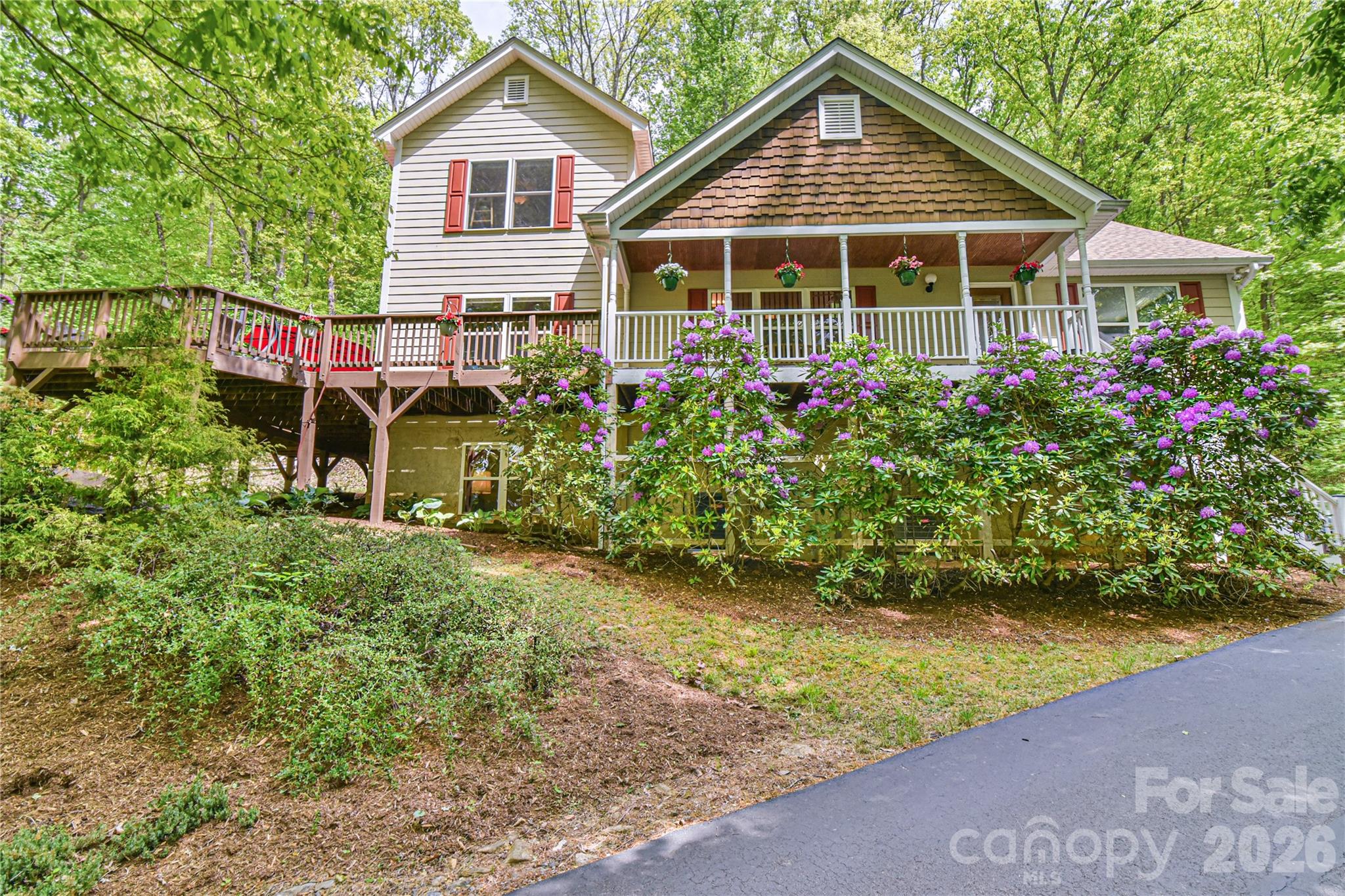 Live the mountain lifestyle… beautiful sunsets, an ephemeral cascading waterfall, winter mountain and valley views to Downtown Mars Hill, and a private wooded setting surrounded by nature. Soak in the change of the season on the back deck, front porch, or side deck. This house offers loads of outdoor gathering space. Step inside to a spacious living room with soaring ceilings, cozy fireplace, hardwood floors, and convenient half bath tucked in off the living space. Enjoy a meal in the open kitchen and dining space with windows that bring the outdoors in, stainless steel appliances, breakfast bar, vented hood, recessed lighting, and roomy dining space. Primary suite on main with hardwood floors, jet soaking tub, tiled walk-in shower, dual sinks, and walk-in closet. Upstairs, you’ll find a gracious loft space for recreation or relaxation, two additional bedrooms, and a full bath with tub/shower. The basement offers private space with large bonus room and en-suite full bath with tiled shower and walk-in closet; a great space for guests or home office. The lower-level includes a laundry room with extra storage and oversized 2-car garage. Home comes with Starlink equipment already installed. Come, fall in love with this amazing 2-acre property and tranquil mountain home.