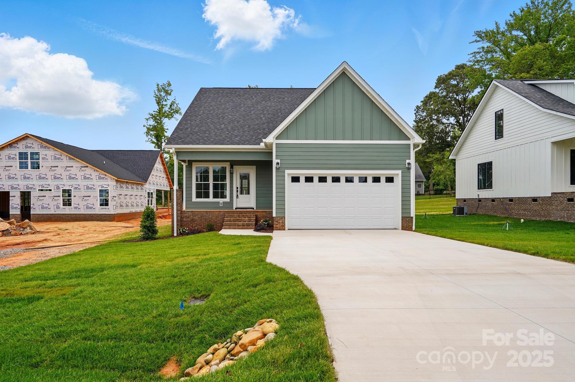 Gorgeous brand-new home with an open, light-filled floor plan and modern exterior featuring durable hardboard siding. The main level showcases a stylish kitchen with quartz countertops, tile backsplash, ceiling-height cabinets, an island, and a walk-in pantry with barn door. The living room features an electric fireplace, perfect for relaxing or entertaining. The spacious primary suite includes dual vanities, a private water closet, and a glass-door shower. Vinyl plank flooring runs throughout the main level. Mudroom/laundry includes custom shelving and a drop zone off the garage. Upstairs offers two bedrooms, a full bath, and a large walk-in attic for storage. Front and back porches will feature sleek white composite railings. Located across from Kings Mountain High School. Some photos virtually staged for inspiration.