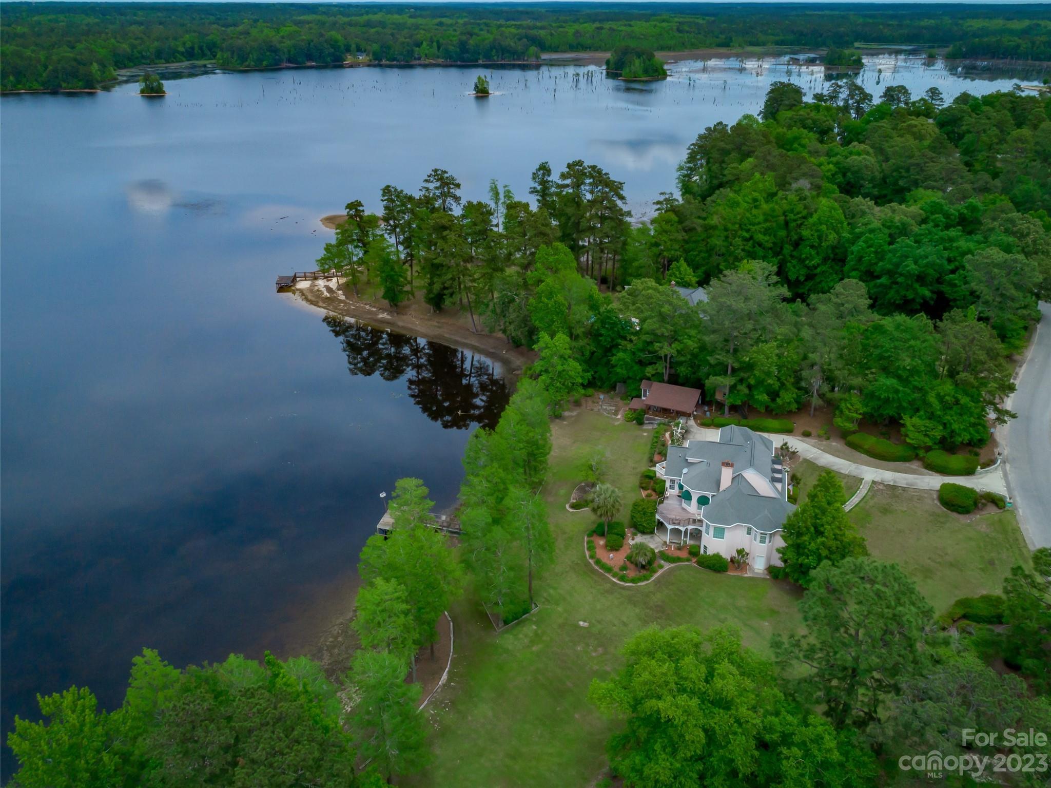 Magnificent waterfront home located in Southgate exudes sophistication & elegance. This custom 5 bedroom home offers a studio and an in-law suite! The living room, adorned with a dome ceiling & gas fireplace, is the perfect spot for relaxing. The kitchen boasts beautiful cabinetry & luxurious granite counters. There is a large breakfast area with breathtaking water views. A large deck is just off of the breakfast area is the perfect place to watch those Carolina sunsets. Off of the kitchen is a butler's pantry & wet bar that conveniently connects to the dining room. The primary suite is on the main floor & features a large bathroom with a jetted tub, water closet, shower & walk-in closet. Upstairs you will find 3 additional bedrooms. Downstairs is an entertainer's dream featuring a gas fireplace, bar area, sauna & French doors leading out to a covered patio area. You'll love the 427sf studio with exposed wood beams, new roof & antique sink! Call for a private tour.