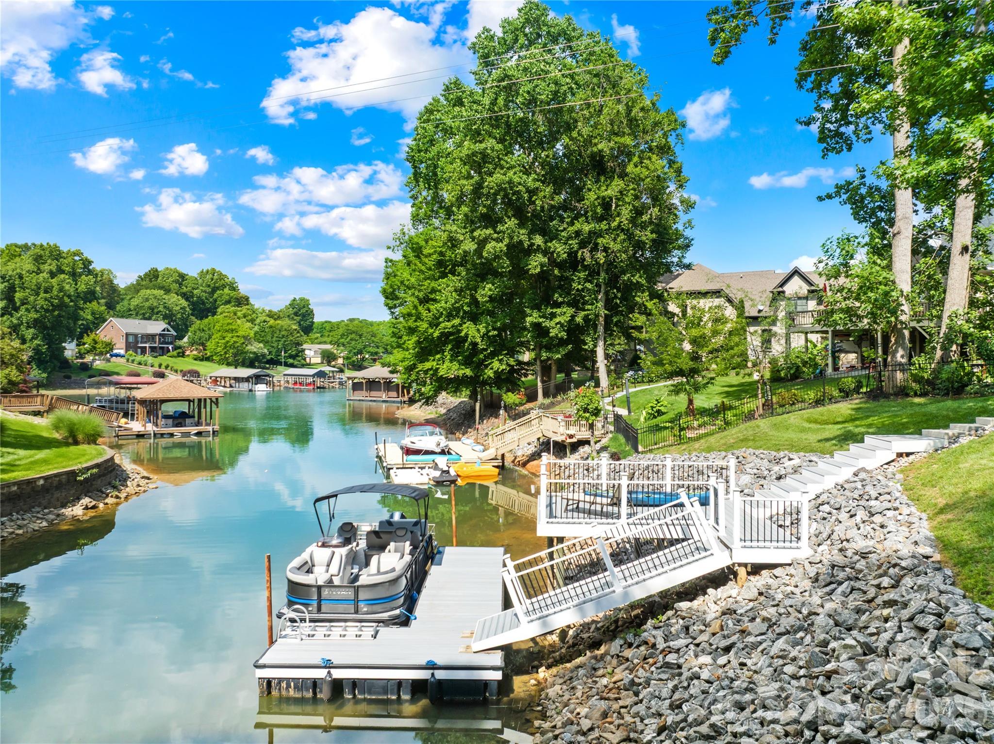 Stunning full-brick waterfront retreat with a private dock and modern upgrades! This 4-bedroom, 3.5-bath home features the primary suite on the main level, complete with new hardwood floors, custom cabinetry in both walk-in closets, and a fully renovated bathroom with custom tile work, a soaking tub, heated floors, and designer cabinetry. Upstairs, you'll find three bedrooms, including one ensuite, and a newly remodeled secondary bathroom with a fully tiled shower, new tile flooring, and a new vanity. A versatile bonus room offers flexible space for a gym, office, media room, or playroom. Additional updates include a fully encapsulated crawl space with a dehumidifier, a newly insulated garage door, and custom garage storage. The dock and riprap were replaced in 2024. Roof, HVAC & Furnace Units (2022). Enjoy your private waterfront setting along with community amenities, including a clubhouse, pool, and boat storage. Thoughtful renovations, functional design, and waterfront access provide the perfect balance of comfort and convenience with easy access to Charlotte. This is one you don’t want to miss!