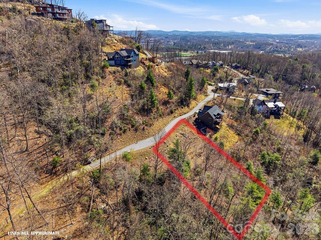 Discover an exceptional opportunity to experience long-range, year-round mountain views from this .90-acre homesite in the sought-after gated community of The Boulders. This is an ideal setting for a custom luxury residence surrounded by natural beauty and distinguished homes. With no required timeline to build, you have the flexibility to design and construct your dream mountain retreat at your own pace. The seller has completed much of the preliminary work, making it easier to begin the building process and bring your vision to life. Most homes within the community are luxury residences valued at over one million dollars, reinforcing both the quality of the neighborhood and the investment potential. This property offers the perfect canvas for a thoughtfully designed home that maximizes the surrounding mountain scenery, whether you envision expansive outdoor living spaces, walls of windows, or a peaceful retreat immersed in the landscape. Enjoy the privacy and prestige of mountain living while remaining conveniently close to the cultural, dining and recreational opportunities of Hendersonville – only 6 miles to Downtown or 9 miles to the Asheville airport. This is a rare chance to secure a premier lot in one of the region’s most desirable luxury communities and begin planning the mountain lifestyle you’ve been dreaming about.