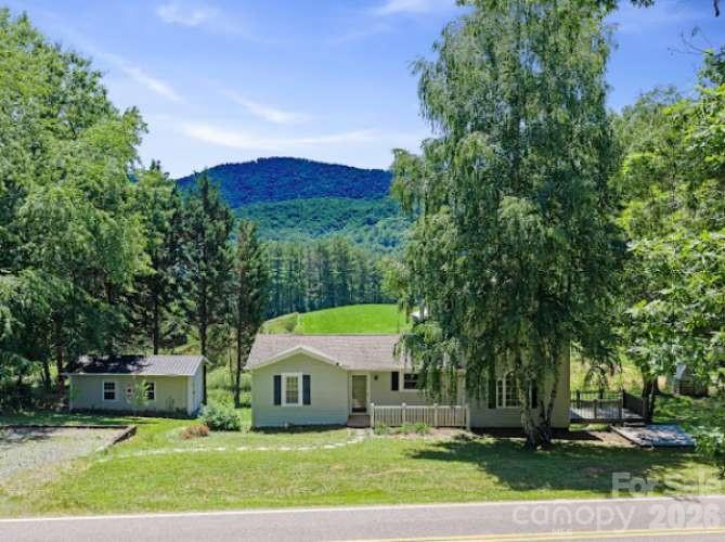 Charming Leicester farmhouse with beautiful mountain views and flexible living space! This well-maintained 4BR/3BA home offers the perfect blend of country charm and modern updates. Recent improvements include fresh interior and deck paint, new vinyl flooring in Kitchen and in the spacious remodeled primary suite. Three bedrooms are located on the main level, with a private primary retreat upstairs. The lower-level tiled Spare room with exterior entrance and full bath offers endless possibilities for a home office, gym, guest space, or second living area. Enjoy relaxing and entertaining on the expansive deck overlooking peaceful countryside views. Additional features include beautiful hardwood, vinyl, and tile floor and storage building/workshop, buried utilities, 4-bedroom septic. Home includes a 2001 addition for a large Primary bedroom and workshop. Conveniently located just a short drive to Asheville while offering privacy and tranquility.