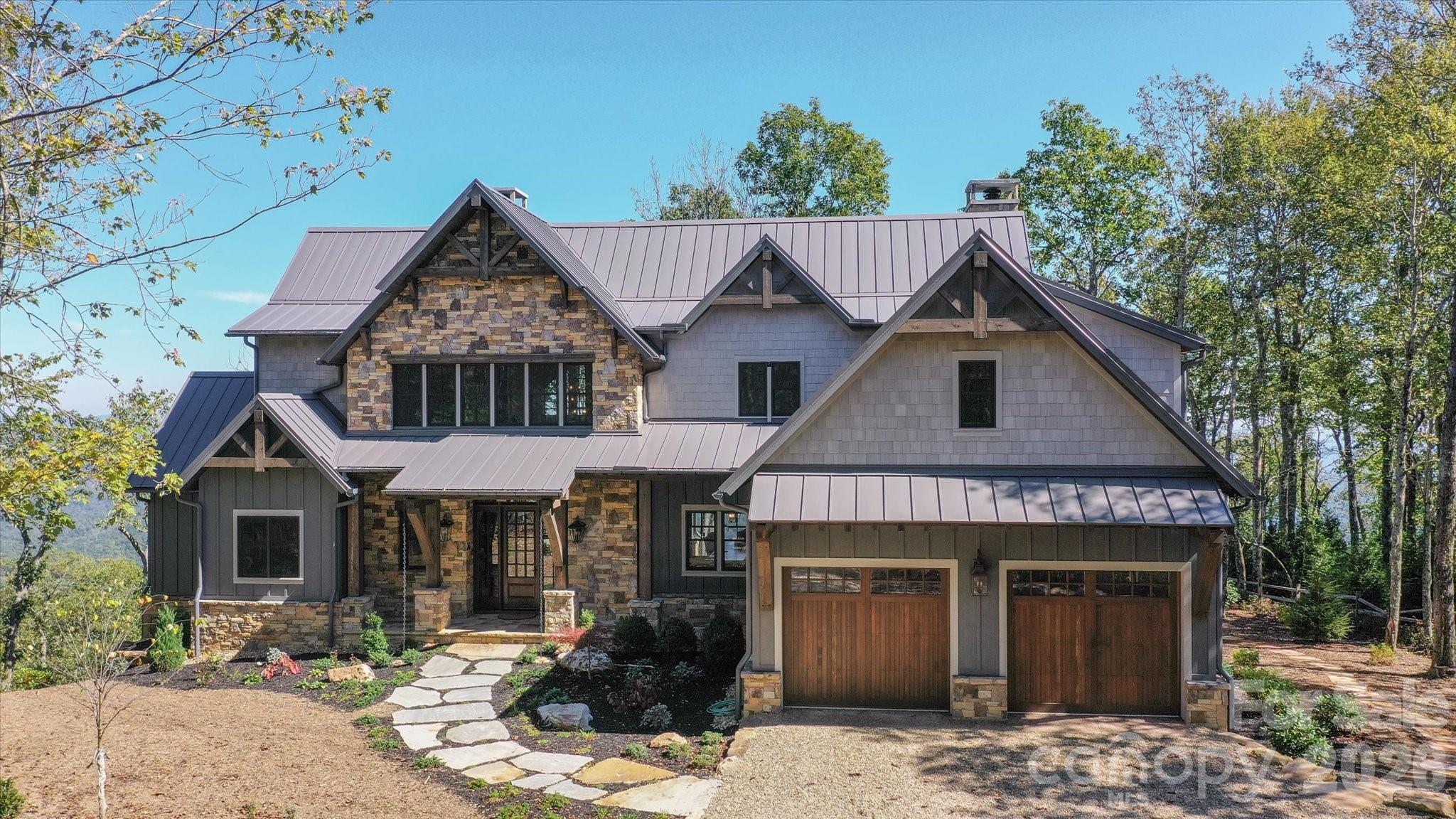 This nicely furnished custom home in the Meadow Ridge section of Lake Toxaway Estates sits on a double lot totaling over 5 acres and is turn key, waiting on you.  Watch gorgeous sun rises to the east while also overlooking incredible mountain and lake views.  With special attention to design, this one of a kind home features reclaimed wood floors with radiant heat, stacked stone fireplaces and accent walls, main level living and so much more.  The exquisite design elements including arched beams and doors, make this home both cozy and inviting.  The primary suite boasts a stone fireplace and large walk in closet.  Each bedroom has an en-suite bath.  Enjoy the views from nearly every room in the house.  With a large porch complete with its own fire place, you can relax and take in the vista. The lot is nicely landscaped and also includes a nature trail for you to enjoy. It is also convenient to the playground and Meadow Ridge Pavilion.   This home was completed in 2025 and is perfect for the discriminating buyer looking for that special place to call home. Property has a whole house 26KWgenerator with an automatic transfer switch and a 10 year extended warranty.