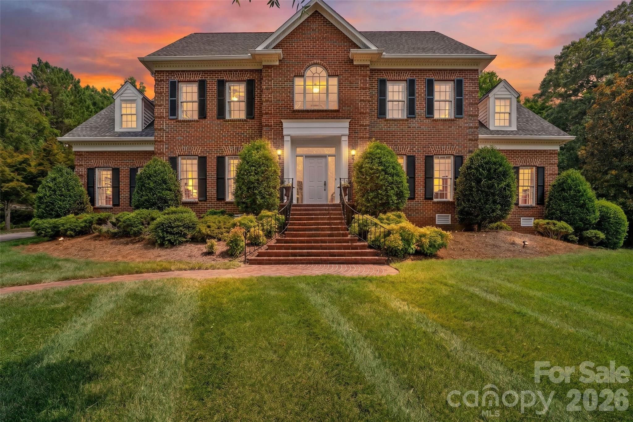 They just don’t make them like this anymore. Welcome home to 2976 Kaneland Court, a thoughtfully crafted all-brick estate perched on one of the most private, expansive lots in sought-after Harlinsdale. This home is designed for a life well-lived, offering intentional spaces to host, work, and play. The main level greets you with a picturesque grand stairwell, perfect for capturing family moments over the years. The dining room hosts eight guests or more, and flows to the sunny eat-in kitchen with ample storage, wall oven and microwave, 5 burner gas cooktop, walk-in pantry and large island. Whether you are finding focus in the quiet, office featuring built-in bookshelves, enjoying a morning coffee in the sunroom with oversized windows and gorgeous views of the mature landscaping all year long, or hosting friends around the wet bar and fireplace in the living room, every corner offers comfort and charm. The screened-in porch and guest room with full en-suite bathroom round out the lower level.  The primary bedroom rests upstairs with dual walk-in closets, luxurious bathroom with spacious walk-in shower, whirlpool tub, dual vanities and plenty of storage. Three more guest rooms and full bathroom with separate tub and shower are also found upstairs, along with additional walk-up attic access. Above the three car garage sits over 700 square feet of a secondary living area with its own bathroom, which can be used for a variety of needs. The yard is partially fenced, private, and full of 36 varieties of camellias and azaleas, along with mature maple trees. This exceptionally built home is a must-see in person. Please see attachments or reach out to the listing agent for the full list of features.