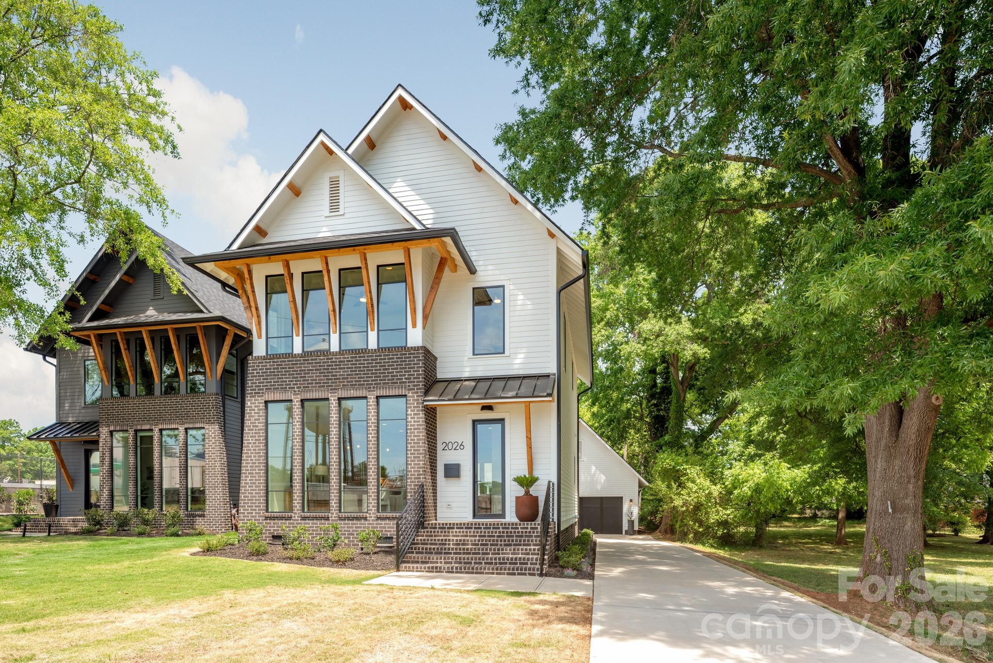 Welcome to 2026 Washington Avenue in Charlotte's Historic McCrorey Heights Neighborhood. This new home was developed with PRIDE and INTEGRITY by MBH Construction, a local Builder known for unique, custom homes built with high quality materials, precision and care. This modern home features an open plan with spacious, natural light-filled rooms, tall ceilings and premium finishes. Fresh and curated interior elements includes Oak site-finished matte hardwood floors, designer tile/lighting/plumbing fixtures, custom kitchen/baths, and much more. The floor to ceiling windows in the dining room provide the perfect viewing for evening sunsets and the uplit West End water tower. Kitchen features European cabinetry, quartz counter tops with waterfall island, under-cabinet lighting and upgraded appliances including 36” gas range and built-in refrigerator/freezer. Wet bar with wine fridge. Custom pantry with counter space to create an in-home destination for your espresso-making skills. Private primary bedroom and en-suite bath with wide dual vanity and large walk-in shower with multiple shower heads. Even more: tankless gas water heater, floored attic spaces and spray foam insulation. Outside, this home has curb appeal galore with numerous architectural details including brick feature wall and foundation, cedar accents, exposed soffits/rafter tails/brackets, Pella® windows, nightscape lighting. Concrete patio for entertaining. Oversized 24 x 24 garage with 50 AMP electric car charging outlet big enough for 2 large vehicles and space left over for your storage needs. Just outside of Uptown Charlotte and convenient location close to major highways and CLT airport. 2-10 Home Warranty included.