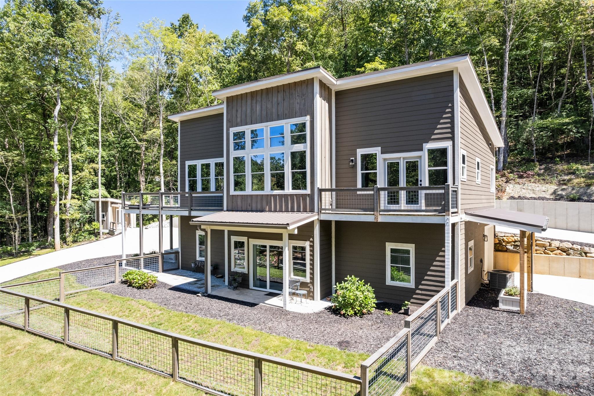 Amazing & Modern Mountain Living in the Great Smoky Mountains! This contemporary home's clean lines, expansive windows, and open-concept spaces seamlessly blend modern design with serene mountain living. With main-level living, a deck off the kitchen, a pull-through, double-car basement garage, a concrete, circular driveway, and a fenced-in yard area, these incredible custom finishes are just a foretaste of all this home has to offer. Downstairs has 2 bedrooms and a bathroom, with an area for gathering and enjoying each other, storage, and the garage. Located in Otto, you can quickly zip down to Clayton or Atlanta, hike the many AT trails in Macon Co., shop the trends in Franklin, or explore Harrah's Cherokee Casino, the GSMRR, and other Smoky Mountain treasures. A rare opportunity to own a besoke, modern home in one of NC's most beautiful mountain regions!