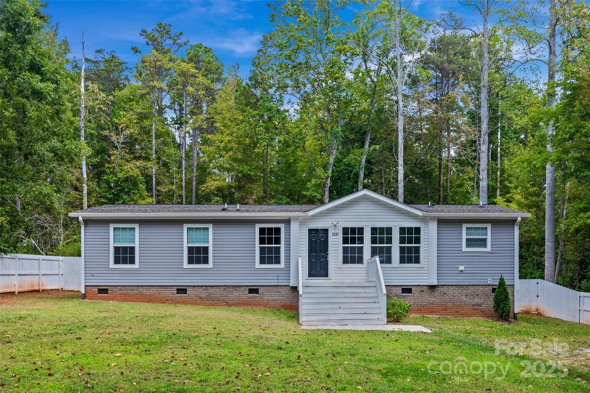 Welcome to country living at its finest! This like-new 3-bedroom, 2-bath ranch sits on a peaceful .7-acre lot surrounded by trees, offering both privacy and charm. Inside, you’ll love the open layout featuring a gorgeous kitchen complete with an oversized island, stainless steel appliances, and a pantry for extra storage. The spacious bedrooms and bathrooms provide comfort throughout. Step outside to the patio and enjoy a spacious fenced-in backyard, ideal for those furry friends and perfect for entertaining.