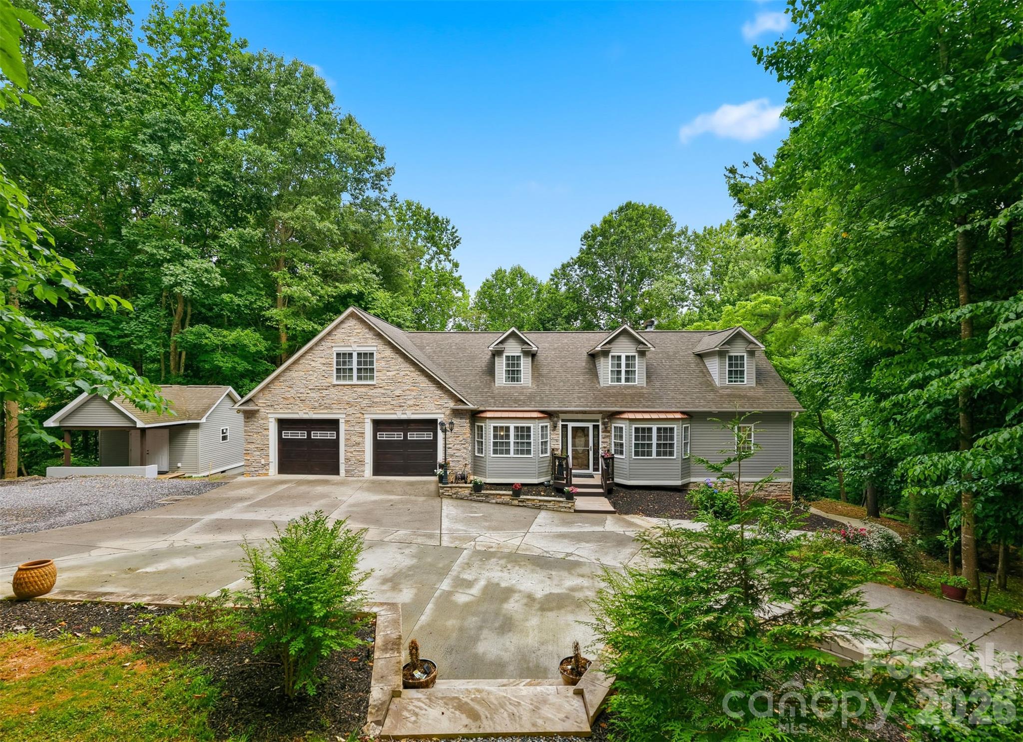 Tucked back on a wooded lot in Statesville, 176 Charis Ln gives you the privacy and space people are always looking for. The home has a great first impression with its stone exterior accents, large driveway, attached garage, mature trees, and peaceful setting.

Inside, you’ll find a warm and comfortable layout with plenty of room to spread out. The main living area has a rustic feel with wood accents, a stone fireplace, detailed ceiling work, and French doors leading out toward the backyard. The kitchen offers wood cabinetry, granite countertops, bar seating, tile flooring, and easy access to the outdoor space.

The home offers multiple bedrooms and updated bathrooms, along with three bonus rooms that give the next owner a lot of flexibility. These spaces could work well as home offices, guest rooms, playrooms, workout rooms, hobby spaces, media rooms, or extra storage depending on what you need.

The finished lower level is one of the standout features of the home. It includes additional living space, a kitchenette, full bathroom, sauna, and its own exterior access, making it a great setup for guests, extended family, entertaining, or just having a separate space to relax.

Outside, the wooded backyard creates a private feel, with a screened porch, patio area, retaining walls, garden space, and a detached storage building. It feels tucked away, but still keeps you close to Statesville, shopping, dining, and major roads.

With its flexible floor plan, finished lower level, garage space, wooded setting, and three bonus rooms, this home offers a lot more than the average property. It’s a great option for anyone needing space, privacy, and room to make the home fit their lifestyle.