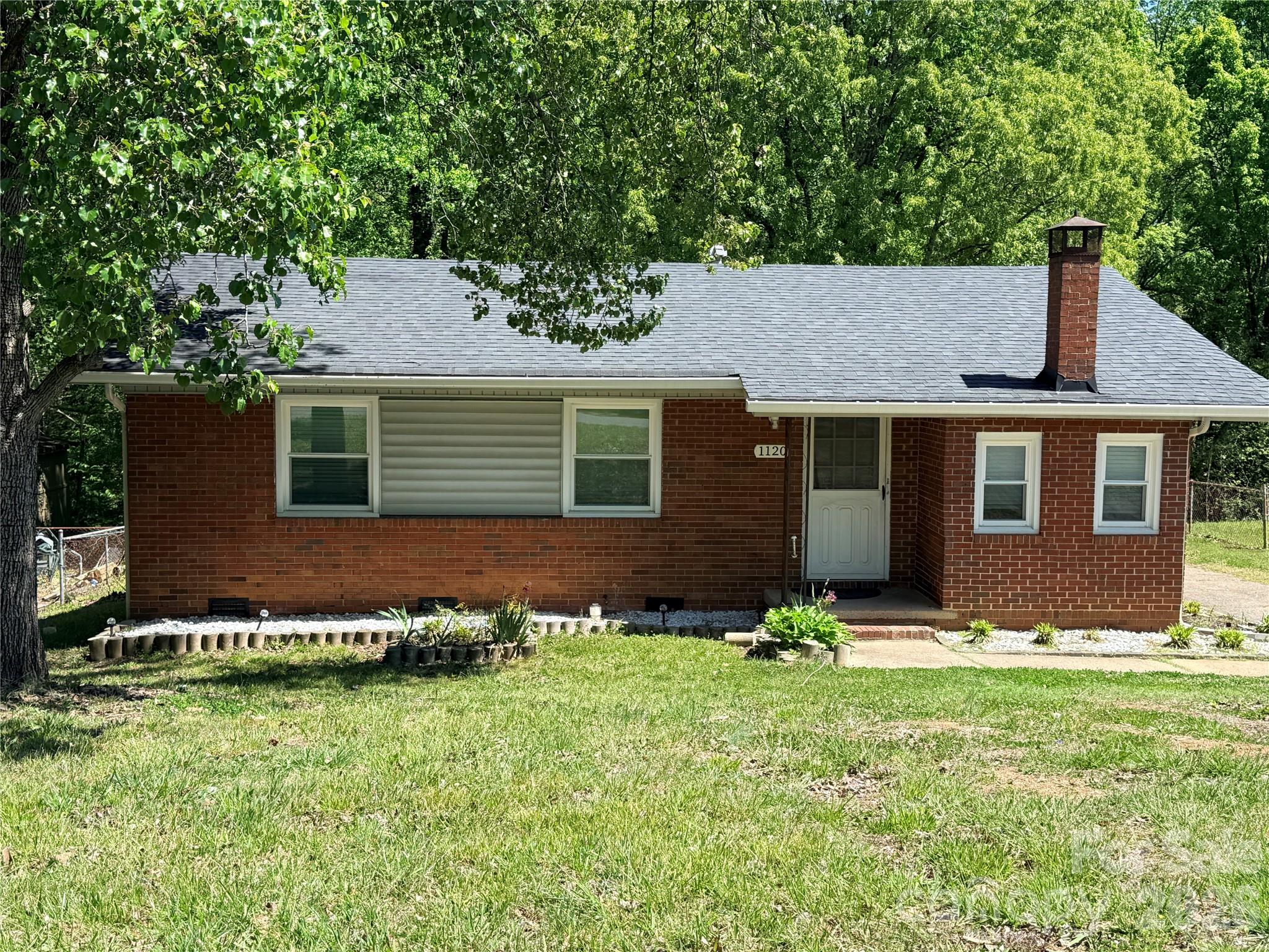 4-bedroom, 2-bath brick ranch just outside of Charlotte. With hardwood floors and fresh paint throughout, this home offers a comfortable layout that works well for both everyday living and entertaining. Inside, you'll find a bright living room that flows right into the kitchen, complete with generous cabinet storage and a dining area. The primary bedroom includes a private en-suite bath and a large closet, while the secondary bedrooms are nicely sized and share a full bath. Out back, the fenced yard and added wooded backdrop create a sense of privacy along with plenty of room to enjoy the outdoors. Conveniently located just 5 miles from CLT Airport and less than 8 miles from Center City, this home puts you close to all that Charlotte has to offer.