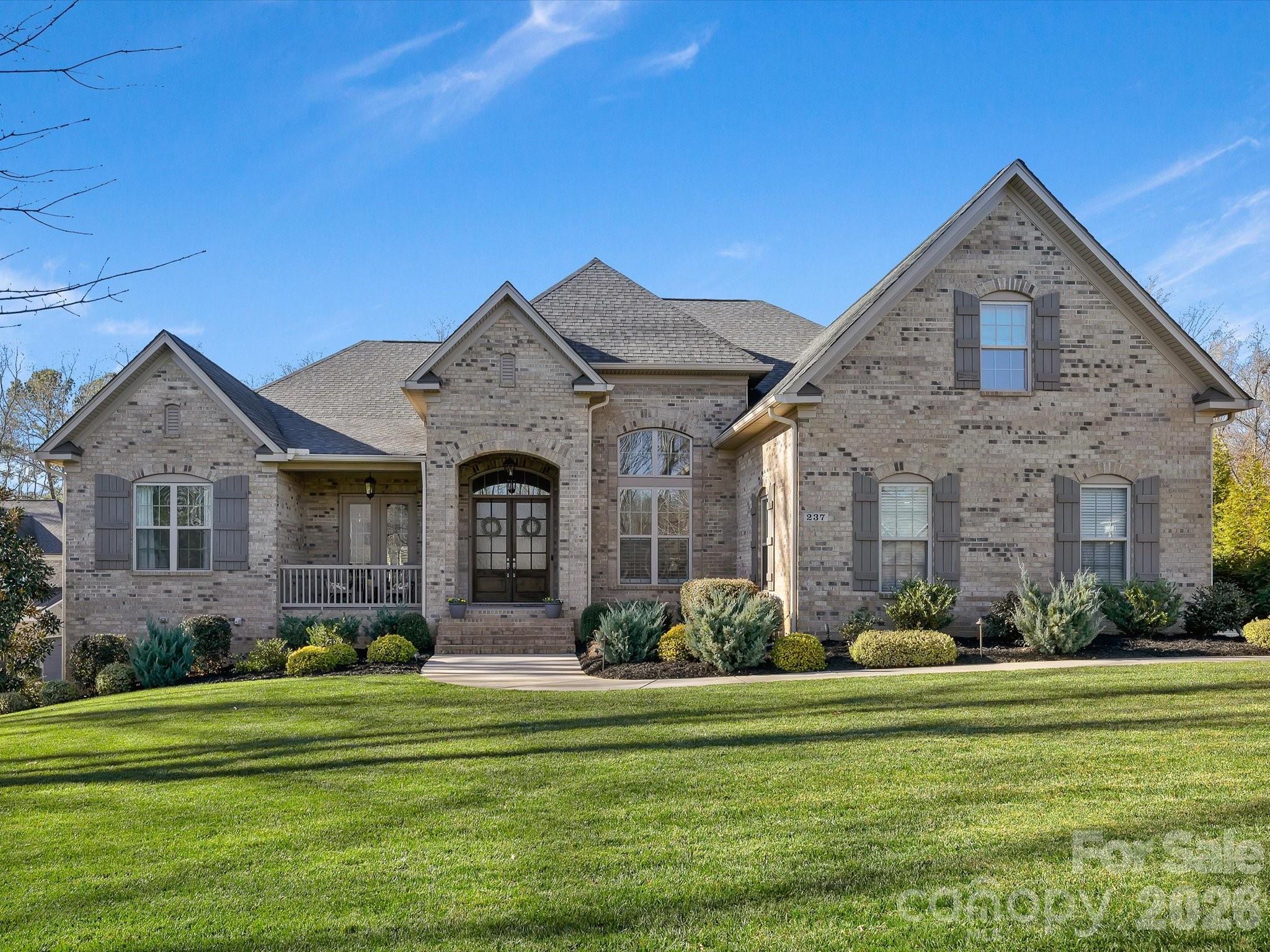 This stunning home welcomes you with custom trim work and high-end finishes throughout. Enjoy outdoor living at its best with a heated in-ground saltwater pool and spa, plus irrigation.
The gourmet kitchen features an oversized island with bar seating, gas cooktop with vented hood, custom lighted cabinetry, soft-close drawers, herringbone backsplash, and a dedicated coffee bar. The kitchen opens seamlessly to the family room, creating an ideal space for entertaining.
The primary suite is located on the main level and offers a oversized walk-in closet and spa-like bath. The main floor also includes an office/den with French doors, formal dining room, lofted family room with built-ins and fireplace, screened porch, open deck, laundry room with cabinets, counters, and sink, plus three additional generous bedrooms—each with walk-in closets. A bonus room and custom drop zone add everyday functionality.
The finished lower level is perfect for extended living or guests, featuring a full kitchen, family room with fireplace, second primary suite, workshop, flex space and pottery studio (or convert to a home theater) with French doors, and a dedicated gym. Completing the home is a finished four-car garage with two car lift and  epoxy floors.