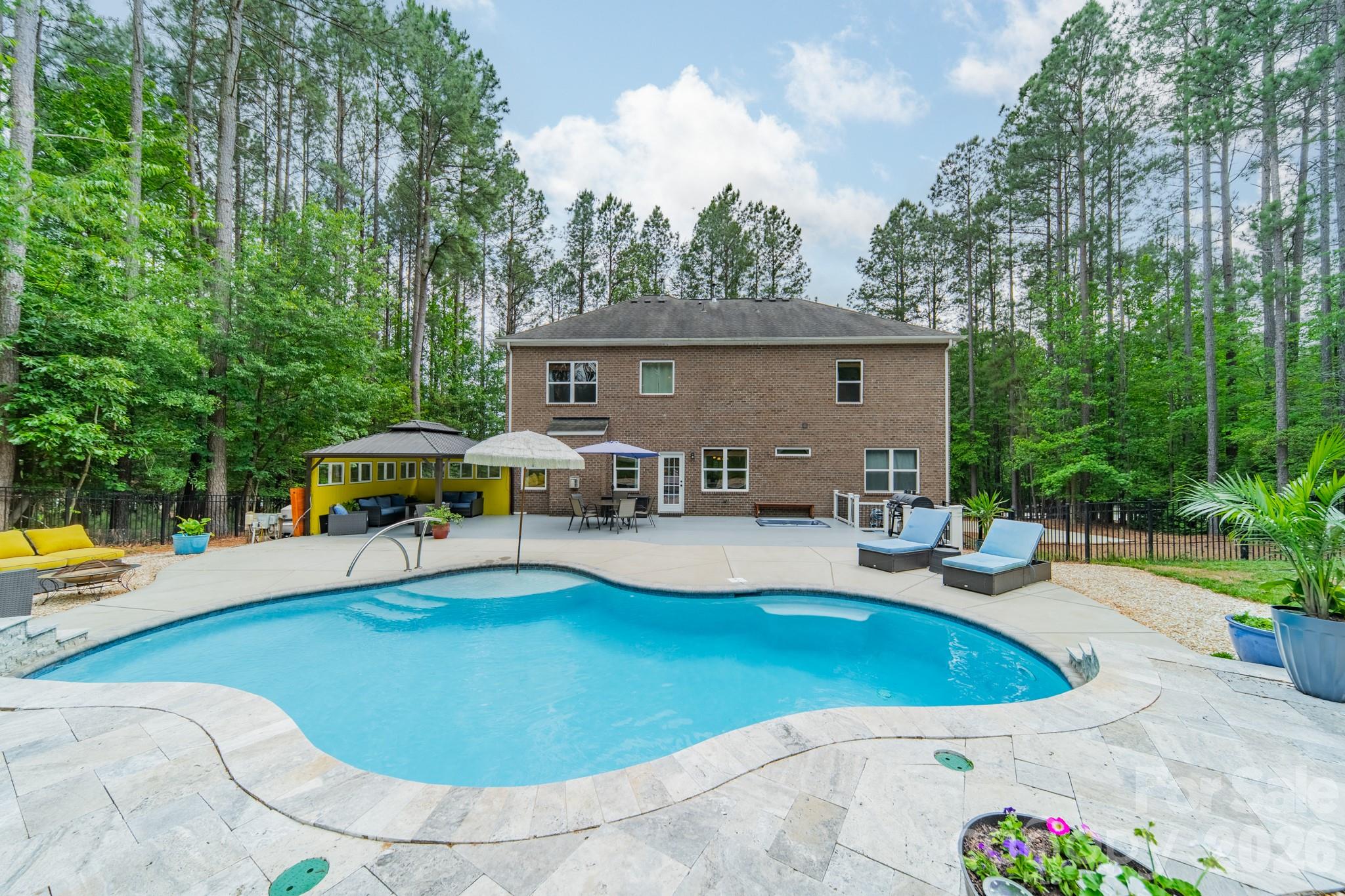 PRICE IMPROVEMENT! Welcome to your own private Lake Norman retreat in beautiful Troutman, NC! Sitting on over an acre with lake views, this 5 bedroom, 4.5 bath home brings together luxury, space, and the kind of backyard made for peace & relaxation. With over 3,400 square feet, there’s room for everyone to spread out while still feeling warm and inviting. Inside you’ll find an open concept living room with fireplace, beautiful kitchen with island and breakfast area, half bath, private dining room, and formal living/office/or playroom area. Also on the main level, a private guest/in-law suite with full bath. Upstairs you will find a loft area currently serving as a home theater, a spacious primary suite with ensuite bath, dual vanities, and an oversized closet. Each bedroom thoughtfully laid out, bedrooms 3 & 4 with Jack and Jill bath and bedroom 5 with its own dedicated bathroom. The heated saltwater pool, hot tub, oversized patio, mature trees, and the sound of nature create the ultimate backyard oasis with serious staycation vibes... you will never want to leave! There are also friendly deer that make a visit! Whole home generator incase power goes out that instantly switches over. There’s also a spacious two-car garage, oversized driveway with plenty of parking, and a detached tiny home/storage building with endless possibilities. 
If you’ve been searching for a lifestyle like this in Lake Norman, this Troutman gem checks all the boxes. Schedule your showing today, homes like this don't last long.
