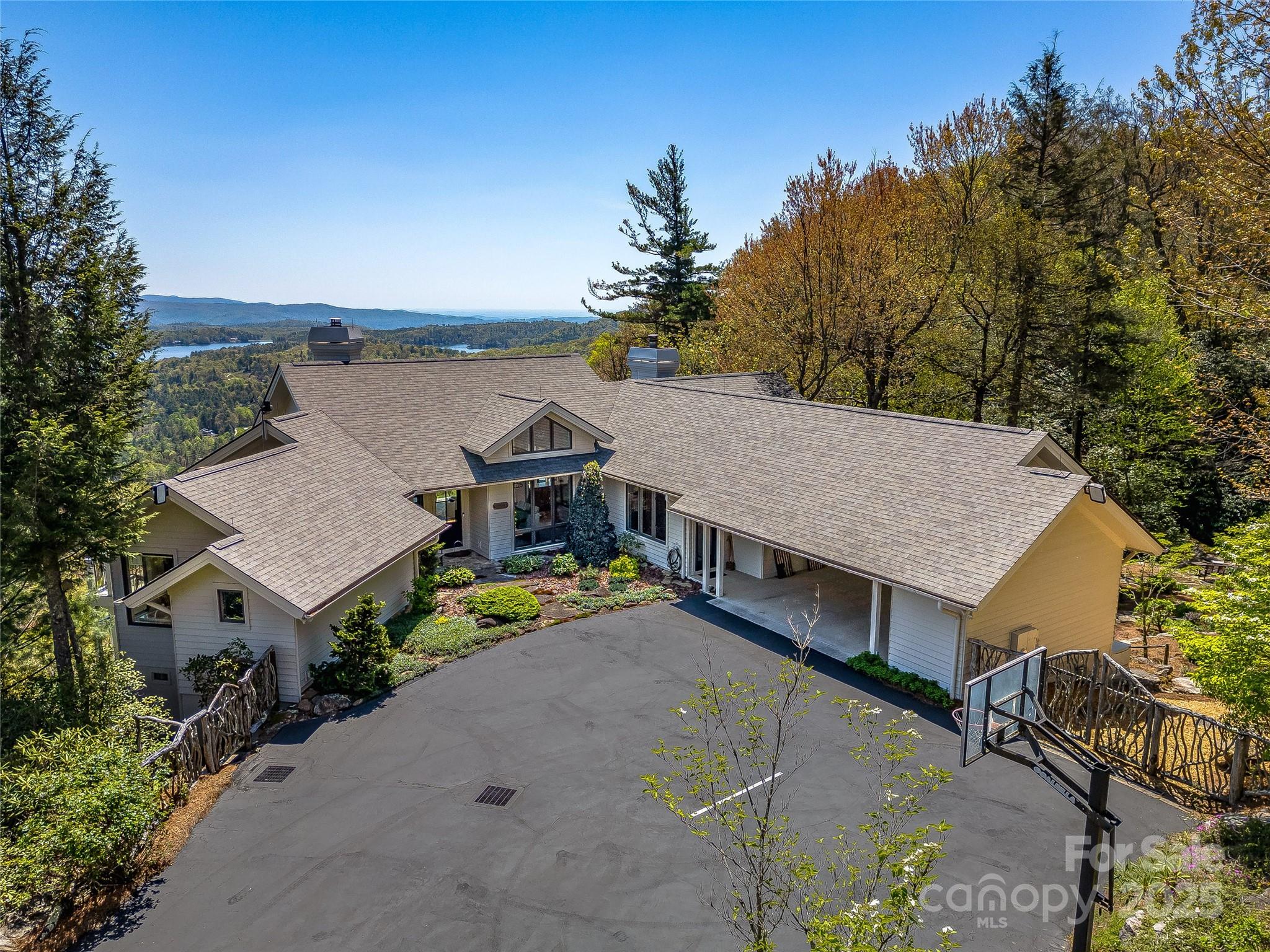 Welcome to your perfect mountain escape—an Al Platt designed masterpiece nestled on 3+ meticulously landscaped acres. This extraordinary home blends timeless architecture with nature's serenity, offering a retreat from the everyday. Step inside to an open floorplan flooded with natural light from an abundance of windows framing sweeping, unobstructed views of the surrounding mountains. Whether you're relaxing in the spacious living area, entertaining by the indoor or outdoor fireplaces, or enjoying the screened-in porch, every corner of this home offers peace and beauty. Outdoors, meandering walking trails lead you through lush gardens, tranquil waterfalls, and a serene pond. Unwind by the swimming pool or take in the natural surroundings from one of the thoughtfully designed sitting areas. With luxurious touches throughout, ample outdoor living space, and the timeless design of one of the region’s most sought-after architects, this home truly is a mountain Shangri-La.