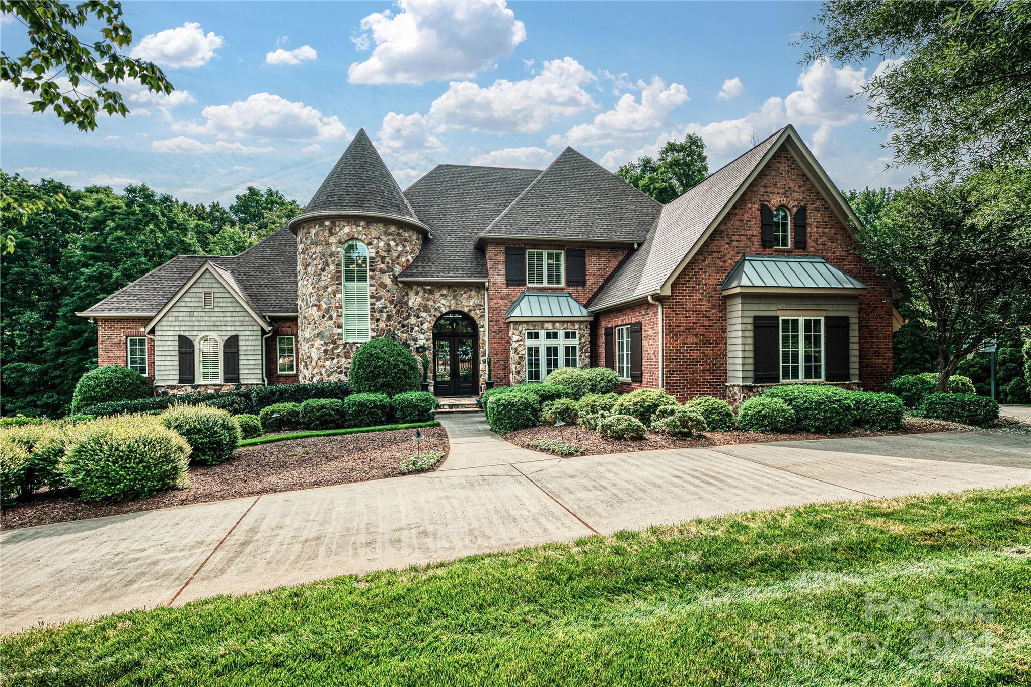 Timeless elegance in this European-style custom residence! Nestled in a prestigious n'hood, this home stands out w/its circular driveway, stone & brick façade, copper roof detail & distinctive turret. The custom interior features high ceilings, arched entryways & a grand curved staircase. Details everywhere! Stunning Kitchen w/extra thick quartzite c-tops, white cabinets, center island, dual dishwashers, Thermador gas cooktop, dual wall ovens, farm-style sink & walk-in pantry. Vaulted, beamed ceiling & stone fireplace in the Family Rm. Custom Butler's pantry, drop zone, workstation & private Office on main. Large second level Bedrooms w/en suite baths. Basement w/new carpet ('23,) built-ins & kitchenette, 2 BRs. INCREDIBLE unfinished space! Completely private, resort-style back yard featuring a heated, salt water, pebble tec pool, hot tub, outdoor kitchen & impressive fireplace. Travertine tile surround.  Covered patio, screen porch & terrace.  Dual, two-car garages. The list goes on!!