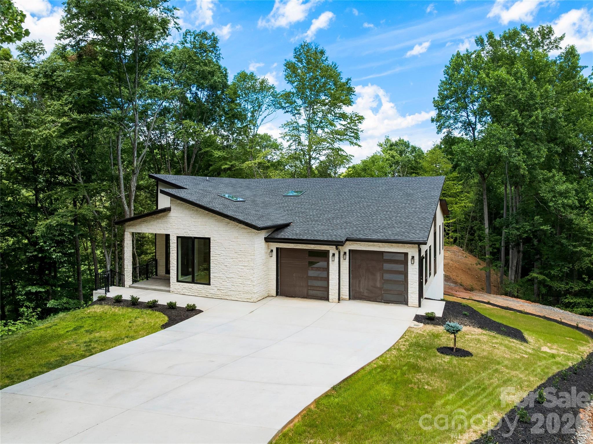 Brand new, custom construction! All the things you are looking for in a new home is available in this lovely, low maintenance beauty! 2 x 6 walls, spray foam insulation, one-level living, luxury appointments…this is your chance to buy a “ready to move into” home with quality features and thoughtful, high-end selections without the long wait of personal customization. The interior in flooded with natural light, due to well placed skylights, high ceilings and soaring windows. Experience pretty, unencumbered wooded vistas through the enormous special order multi-paned glass. No detail was spared in the design of this lovely contemporary home. The location is dreamy on a quiet cul-de-sac in a gated community, and just a short drive to Downtown Asheville. Here you’ll find all of the amenities you seek, as well as all the peace living in the Western North Carolina mountains afford you. Showings start this week!