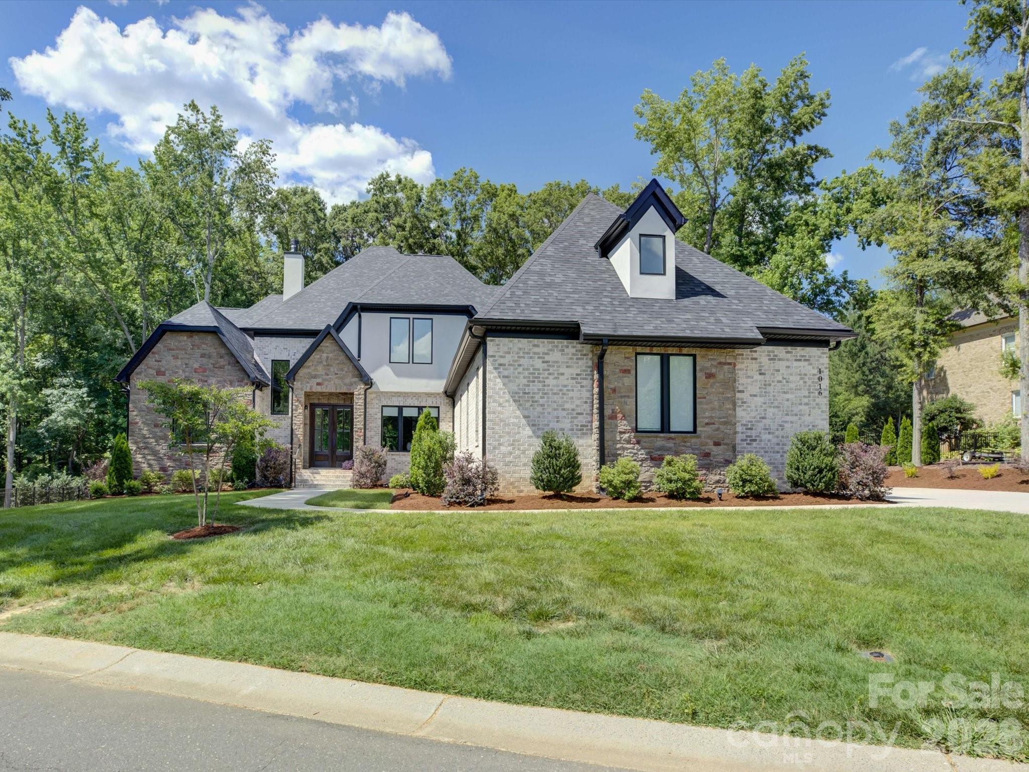 Absolutely stunning home that immediately captivates with it's commanding presence! This impressive property is located in the elevated neighborhood of Gardens on Providence - so close to the conveniences of Ballantyne/Waverly/I-485 AND zoned for the nationally ranked Marvin Ridge schools! Designed for both grand-scale entertaining and refined everyday living, this remarkable home offers five bedrooms, five full bathrooms and a half bath with meticulously curated details throughout. A soaring two-story foyer, modern millwork, and showcase stairway welcomes you inside and sets the tone for the sophistication that unfolds. The main floor offers an airy, open layout with an entertainer's dream of a kitchen including GE Monogram appliances, a walk-in pantry, and a scullery area that complements and provides amazing storage. The primary suite on the main level features a spa-like bathroom with marble flooring and a custom closet system. The main level also boasts a huge laundry and mudroom area that can accommodate the busiest of families + a dedicated private study. Upstairs, you’ll find 3 bedrooms with beautiful, custom ensuite baths and 2 generous flex rooms that can serve as additional bedrooms, a home gym, or a media/billiards room! Don't miss the luxury wet bar in the huge entertainment space over the 3 car garage or the 2nd floor laundry closet! Outside bonus features include a newly screened-in porch overlooking a level, spacious backyard that can easily house a pool and/or sport court, professional landscaping, irrigation and landscape lighting. This high end, move-in ready home completed in 2024 is a lifestyle!