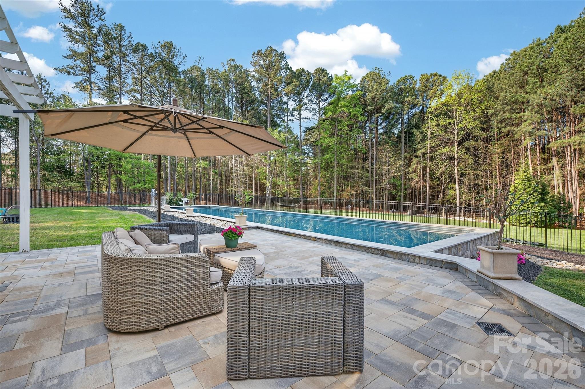 Tucked within The Point, this beautifully situated home offers one of the most peaceful and private backyard settings in the community. The rear lawn feels like a quiet retreat — lush, serene, and naturally screened, with mature landscaping, expansive outdoor living space, and a sense of calm that is increasingly hard to find. 

At the center of the outdoor experience is a resort-style pool setting, complete with a heated saltwater lap pool, travertine decking, diving block, and automated cover. Nearby, the pool house adds valuable flexibility for entertaining, fitness, guests, work, or recreation — creating a backyard environment that feels both private and highly functional.

Inside, the home offers generous spaces, a comfortable floor plan, and flexible rooms that can be utilized in a myriad of ways. The main living areas connect easily to the rear grounds, allowing the next owner to create a home that reflects their own style while preserving what cannot be easily recreated: the lot, privacy, setting, and location. With access to the lifestyle of The Point and Trump National Golf Club Charlotte, this is a rare chance to pair a premier community with a truly special backyard retreat.

Experience The Point, where amenities include a championship golf course, clubhouse, dining, fitness center, tennis and pickleball courts, pools, walking trails, and a vibrant calendar of social events. A minimum membership to Trump National Golf Club is required. Additionally, home comes with a dedicated boat slip lease opportunity.

Welcome Home.