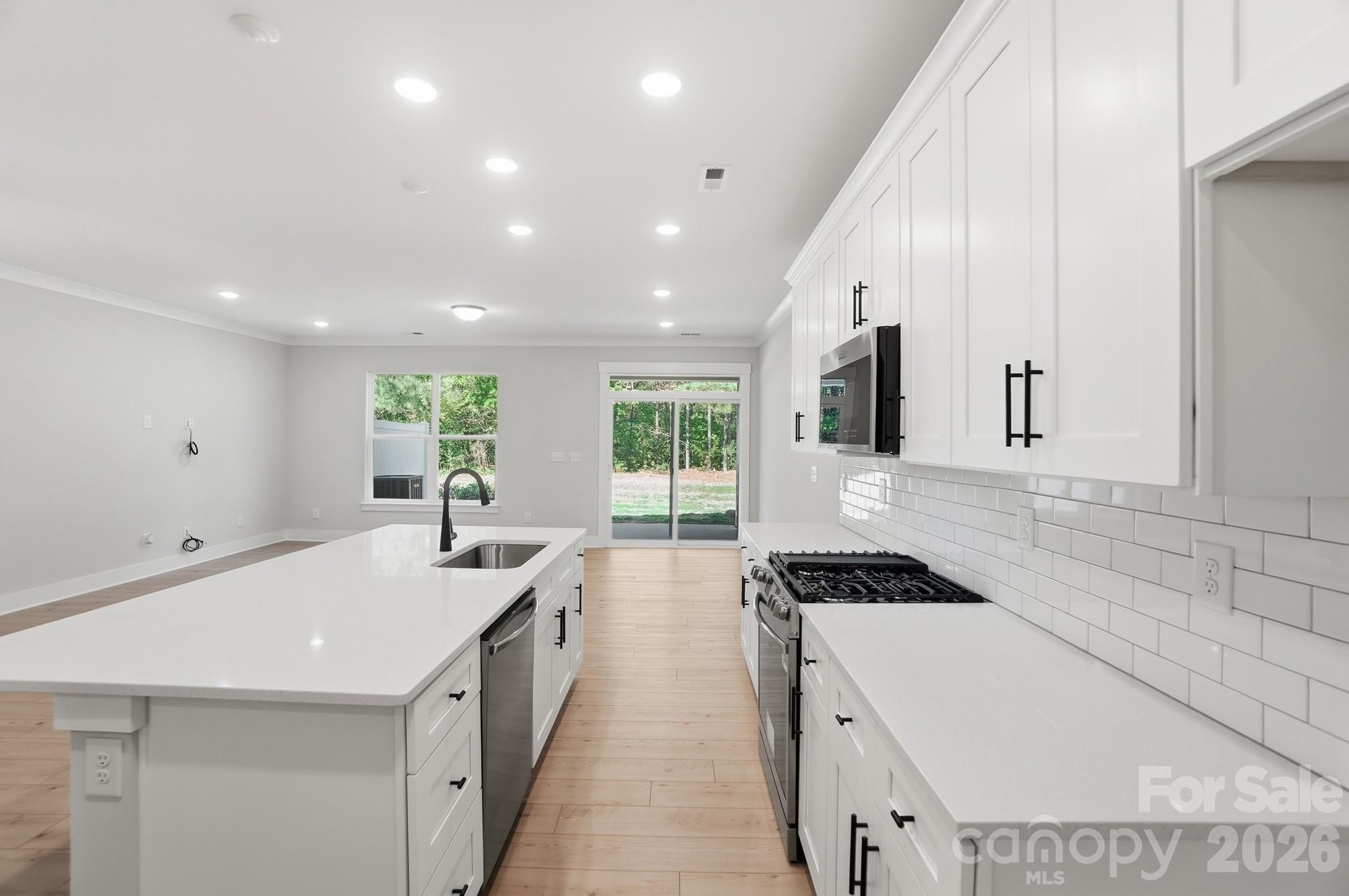 This Ashland plan has 3 bedrooms, 2.5 baths, and more than 1,800 square feet of living space. Enter the home through the foyer with tray ceiling, Craftsman-style trim, and a convenient, beadboard drop zone to see the open kitchen, dining area and family room that walks out to a covered porch. The kitchen features white, Shaker-style cabinets and white quartz counters, a spacious island, white tile backsplash, and stainless appliances, including a gas range. The open main floor has beautiful and durable Enhanced Vinyl Plank flooring throughout. Stairs with composite treads and metal balusters lead upstairs to the loft, bedrooms, full baths and laundry room. The primary bath has a tiled shower with bench seat, dual-sink vanity, and linen closet. The upstairs full bath has a tub/shower combo. Walking distance to shops, eateries, and other conveniences. Visit today!