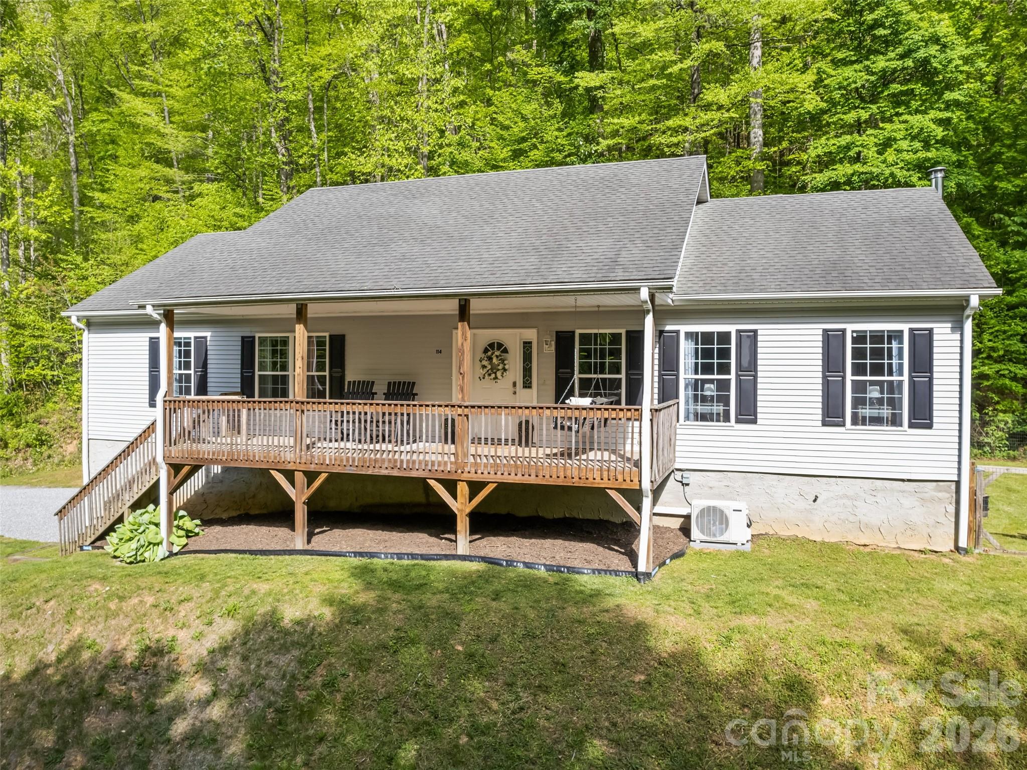 Tucked away in the peaceful mountain setting of Balsam, just over the Jackson County line and adjoining the Blue Ridge Parkway, this move-in ready home invites you to slow down and soak in the beauty of Western North Carolina. Start your mornings on the covered front porch, coffee in hand, listening to the soothing sounds of the nearby creek, and end your days unwinding on the large, private rear deck overlooking your fenced side yard. Inside, a thoughtfully designed split floor plan offers both privacy and spaciousness, fenced side yard. Inside, a thoughtfully designed split floor plan offers both privacy and spaciousness effortlessly into the dining area, creating an ideal space for gathering. The kitchen features abundant cabinetry, stainless steel appliances and intimate dining. The partially finished basement expands your living space with high ceilings, a mini split system, and plumbing already stubbed for a bath—perfect for a recreation room or media space. An oversized double garage provides ample room for storage, hobbies, or a workshop. This home blends comfort, functionality, and a connection to nature.