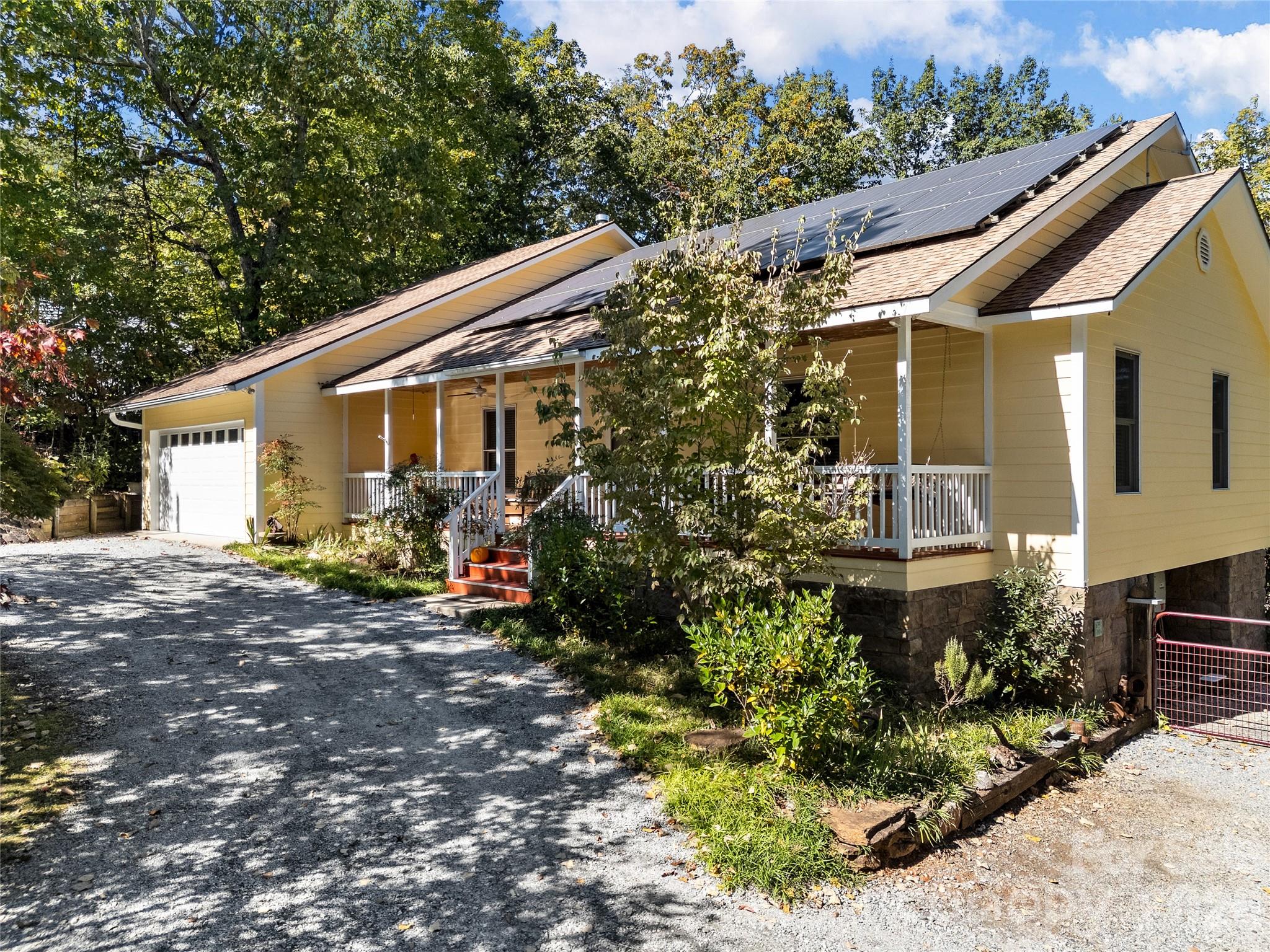 Welcome to Lake Lanier, a desirable community with lake access rights, nestled conveniently between Tryon, NC and Landrum, SC. This surprisingly spacious 2 BR, 2.5 BA home also features a solar system, climate-controlled office, den, studio, laundry room and enclosed loft. The .97-acre lot includes a private fenced-in back yard with YEAR-ROUND mountain views; a concrete patio with awning, and several raised bed gardens. In addition to a 2-car attached garage with work bench, there is a one-car detached garage with power and an exterior water hydrant. There's also a circular driveway and room for an RV or boat on a separate gravel drive. The well-maintained living space offers an open concept floor plan for kitchen, dining area & living room with direct access to the rear screened porch and mountain views. All bedrooms and baths are on the main level as well as the den, office, and laundry room with beautiful hand-hewn flooring throughout much of the main level and six-panel solid wood doors. Primary bedroom has two closets and an en-suite bath. Guest room has walk-in closet and is adjacent to the guest hall bath. Entering from the living room, the office is adjacent to the laundry room with greenhouse window for over-wintering plants, storage shelves, and a half-bath. Eat-in kitchen features gas range/stove, granite countertops, beautiful custom cabinetry, ample storage, a pantry, and a small desk area. Walk out from kitchen to large screened-in porch perfect for outdoor dining with built-in gas grill area complete with vented hood system. Located on the backside of the house with year-round mountain views, it overlooks the patio, small greenhouse, gardens and raised beds. Backyard is completely fenced to keep pets in and deer out. Loft/bonus room (not included in the overall finished SF due to access through the unheated garage) has built in shelves, a mini-split system, and sliding windows that open above the den, offering flexible space for a private office, studio or guest space. There is additional unheated storage space adjacent to the loft. The den has built-in window seats for storage and large windows to take in views and great natural light. From the den, stairs lead to the climate-controlled ~300 sf unfinished basement (not included in the overall heated sf). Beyond that, ~285 sf of unheated/unfinished space with large institutional sink, overhead lighting, and connection to the ventilation system. Both areas have walk-out access the backyard and are perfect for storage, hobbies, or studio. There is also a 400 sf, 7' high walk-out crawl space on this lower level with the furnace, water heater, and storage space for mower, tools, and other seasonal items. Small greenhouse with exterior water hydrant and several raised beds in the back yard are perfect for growing vegetables and/or flowers. Home is equipped with a plug for a generator, to make it easier to keep things running when the power goes out. Acreage includes a separate .26 ac adjoining lot, in case you want to build something else, sell it, or just keep it for added privacy and control of your mountain views. Ask your agent for a copy of the full list of improvements.