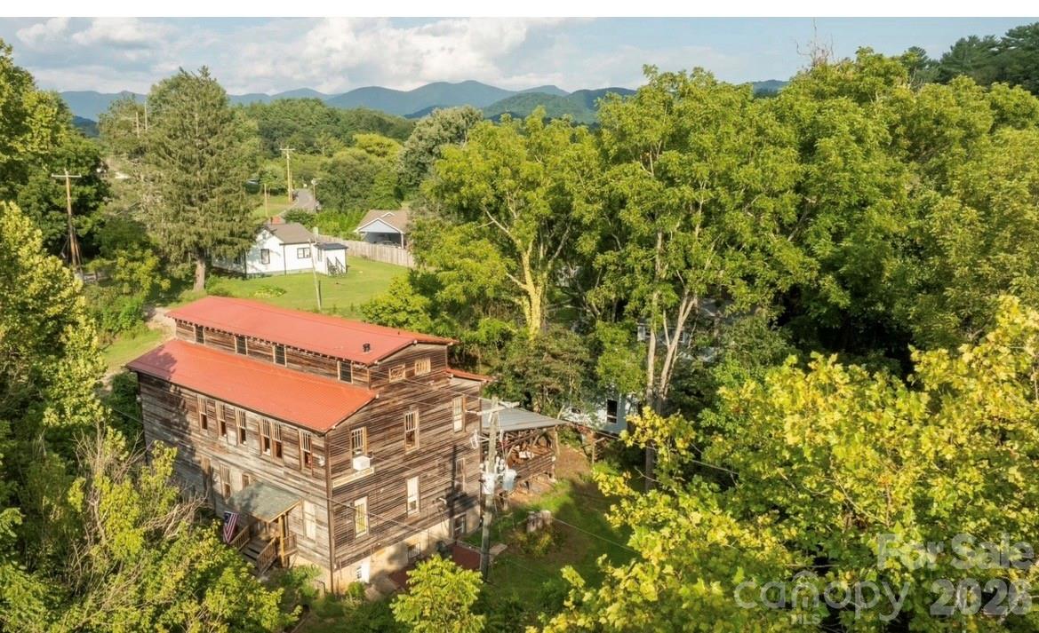 Historic Weaverville Milling Company.  Circa 1914 ...  Rare Opportunity.....150+ year old Grist Mill / former 150 seat Restaurant includes house and cottage, on 5.25 acres, with a private oasis along 1,000 ft. of bold Reems  Creek waterway. Property is ocated in the County for lower taxes & only 10 min. to Downtown Asheville.  Ideal for Private Club, Event Space or Restaurant.... The Mill is over 7,000 sq.ft. + 1,400 sq ft  covered patio. The Old Mill building has  strong local history. Old house (1940s) remodeled w 3 bed /2 bath , and rear deck, large unfinished lower level daylight basement. Old Cottage remodeled w 1 bed and 1 bath , kitchenette approx. 600 SQ Ft with 300 sq ft rear deck.    Zoning allows short term rental and mixed use commercial.   1 Old Mill lane lot zoned EMP, 9 Old Mill lane zoned R-3. Not in Weaverville City limits. Property has City Water,  Sewer & Natural Gas.  Property has flood plain but structures stand up high on land and not impacted during Hurricane Helene. Property has multiple potential uses. Very rare private peaceful sanctuary along the bold waterway. Some photos enhanced with AI to show update potential and residential potential.