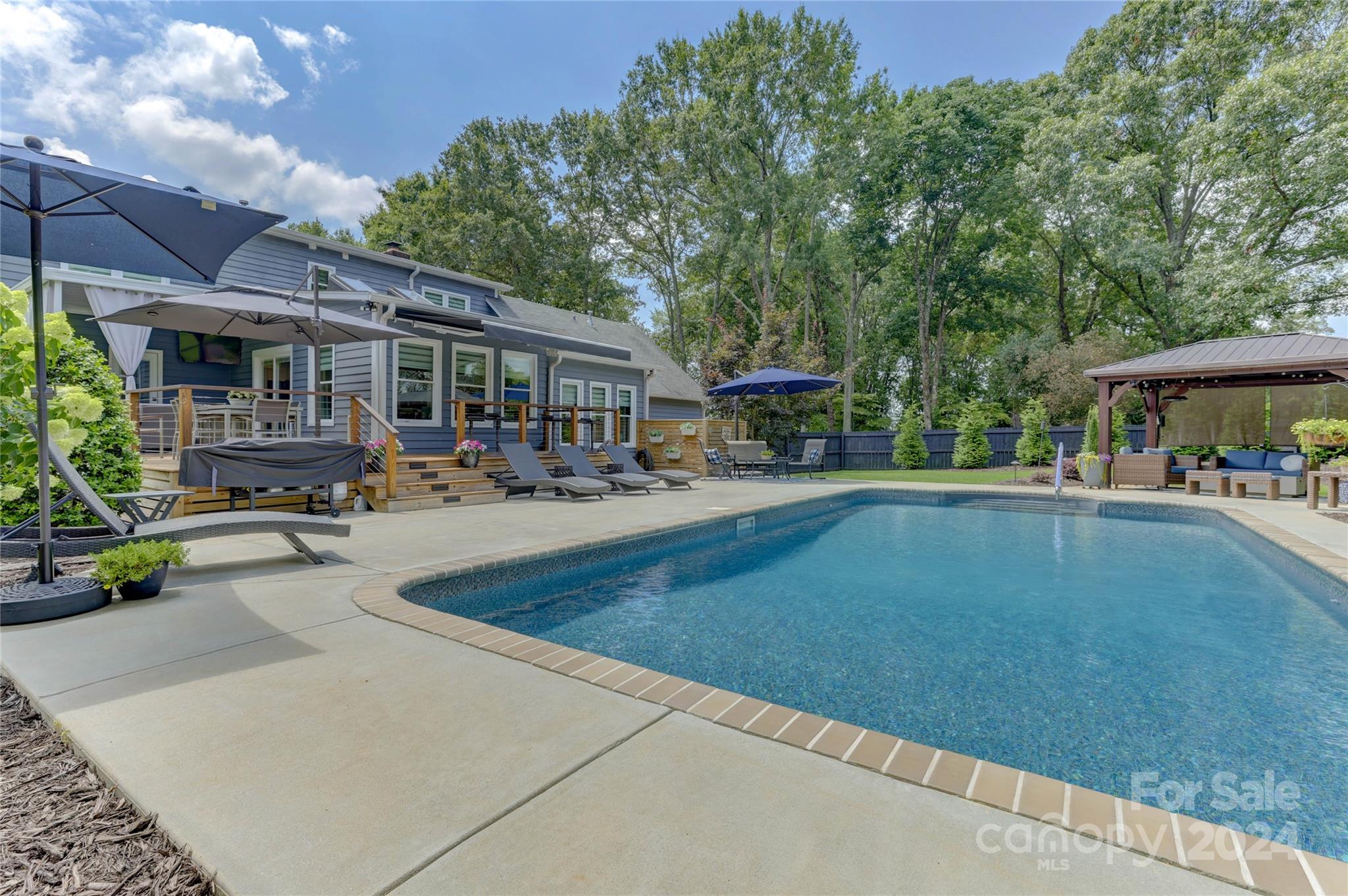 Come see this gorgeous and updated Fort Mill home! The great room features a fireplace and tons of natural light. Enjoy the convenience of the primary bedroom on the main level with a renovated primary bathroom, featuring a luxurious walk-in shower, double sinks, stylish custom built-ins, and a private entrance to the pool deck. The renovated kitchen features SS appliances and a bar with a beverage fridge, overlooking the dining area. A standout feature of this home is the oversized chef's pantry! The main floor features an office and an oversized mudroom with a utility sink. The upstairs boasts three spacious secondary bedrooms and a full bath. Entertain in the expansive backyard with an inviting in-ground pool and gazebo, surrounded by beautiful landscaping with accent lighting. Wired with a 220v power supply for EVs or RVs. Double-hung, energy efficient windows throughout. More than 1500 sq ft of sealed storage beneath the home and in the attic. Convenient access to I-77!