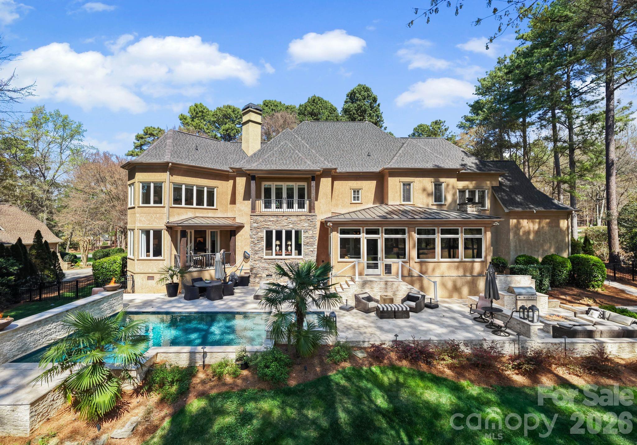 Enjoy sweeping sunset views over the 3rd hole of Trump National Golf Course from this exceptional home tucked within The Point. Set on 0.78 acres with over 5,700 square feet, this beautifully maintained 4 bedroom/4.5 bath residence offers the perfect balance of comfort, style and everyday livability.

The outdoor space is designed to impress, with a resort-style feel that’s ideal for both relaxing and entertaining. A custom Tru North Pools designed hardscape patio ('21) features a sunken fire pit, outdoor kitchen with bar seating, and a saltwater pool and spa—all overlooking the golf course for a truly special backdrop!

Inside, a grand two-story foyer sets the tone, leading into an open and light-filled main level. The living room showcases a fireplace, custom built-ins and expansive views, flowing seamlessly into the breakfast area and a well-appointed chef’s kitchen with granite countertops, updated finishes and ample workspace.

A cozy sunroom with its own fireplace offers a quiet retreat, while the formal dining room with butler’s pantry makes hosting effortless. The main-level primary suite is a true escape, featuring a fireplace, private access to a covered patio, a spacious custom walk-in closet and a spa-like bath with soaking tub and walk-in shower.

Upstairs, a large bonus room overlooks the backyard and course, alongside a secondary primary suite that’s perfect for guests or multi-generational living. Additional bedrooms, a shared bath, and a flexible recreation space provide plenty of room to spread out. Dual laundry rooms on both levels add everyday convenience.

Recent updates include a new roof (2022), EV charger hookup, updated lighting and fixtures, and enhanced landscaping and irrigation.

Living in The Point means access to top-tier amenities through a Social Membership, including dining, fitness, tennis, swimming, and year-round community events. A 12-month leased boat slip is also included, adding even more to the lifestyle.

This is a rare opportunity to enjoy elevated living in one of the area’s most sought-after communities, where every detail has been thoughtfully designed for comfort and connection.
