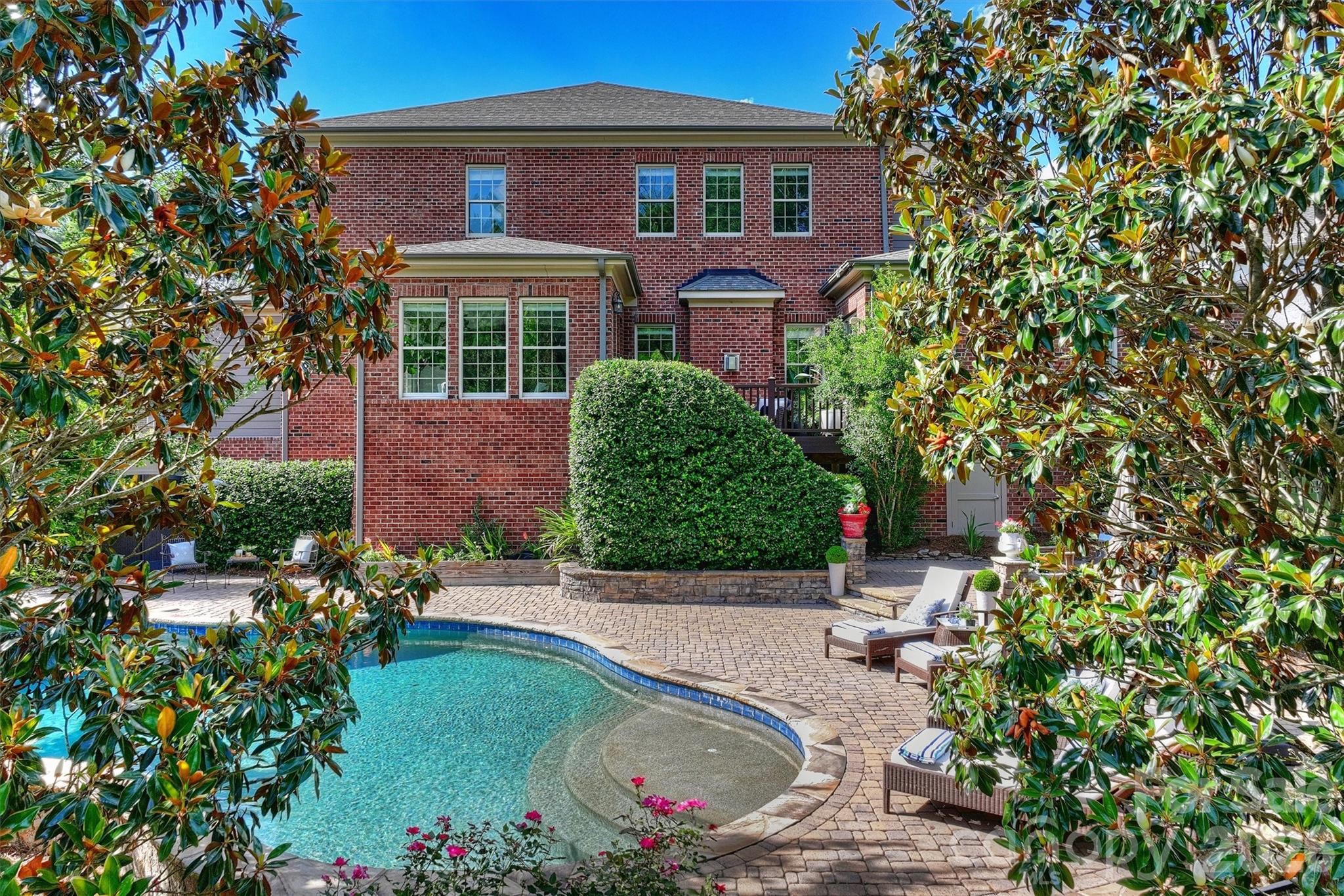 Nearly 5,000 sq. ft. of modern luxury in prime Baxter Village — tucked on a quiet cul-de-sac yet steps from shops, dining and trails. This full-brick estate welcomes you with a spacious front porch and a mahogany front door with 3/4 seeded glass, opening to a dramatic foyer with tray ceiling and modern lighting. Ten-foot ceilings on the main level (9-ft upstairs), hardwoods throughout, plantation shutters, custom draperies, and extensive millwork (tall baseboards, crown molding and picture-frame trim) create a refined, move-in-ready home.

Designed for everyday living and entertaining, the floorplan offers five bedrooms and 5.5 baths — every bedroom with its own en-suite and walk-in closet. The primary suite is a serene retreat with abundant natural light, tray ceiling and a large custom closet; the spa-like bath features dual vanities, a deep soaking tub, frameless glass walk-in tile shower and private water closet. Multiple flex spaces include a loft/library with wall-to-wall built-ins, workout room, music room, media room with tray ceiling and wet bar (sink, beverage fridge, cabinetry), and a bright sunroom overlooking the backyard.

The gourmet kitchen is a chef’s dream: center island, gas cooktop with direct-vent hood, wall oven, large walk-in pantry and adjacent butler’s pantry with built-ins. A great room anchors the main living area with a sleek modern fireplace, sputnik chandelier and built-in ceiling speakers. Practical touches include a mudroom with drop zone, laundry with sink and counters, whole-house water filtration, tankless water heater (2025), two high-end HVAC systems (2025, 2022), and a fully encapsulated crawl space.

Step outside to a private outdoor oasis overlooking green space and The Carolina Thread Trail with direct access to the Catawba River for kayaking and mountain-biking trails. Low-maintenance Trex deck, paver patio with cozy fire pit, fenced yard with irrigation and lush landscaping surround a beautiful free-form saltwater heated gunite pool with tanning ledge and fountains. A 3-car garage provides ample room for vehicles, toys and storage.

This home blends high-end systems, thoughtful design details (arched openings, painted ceilings, designer lighting, chrome hardware) and exceptional indoor/outdoor living in one of Baxter Village’s most desirable pockets. Schedule your showing to experience it firsthand.
