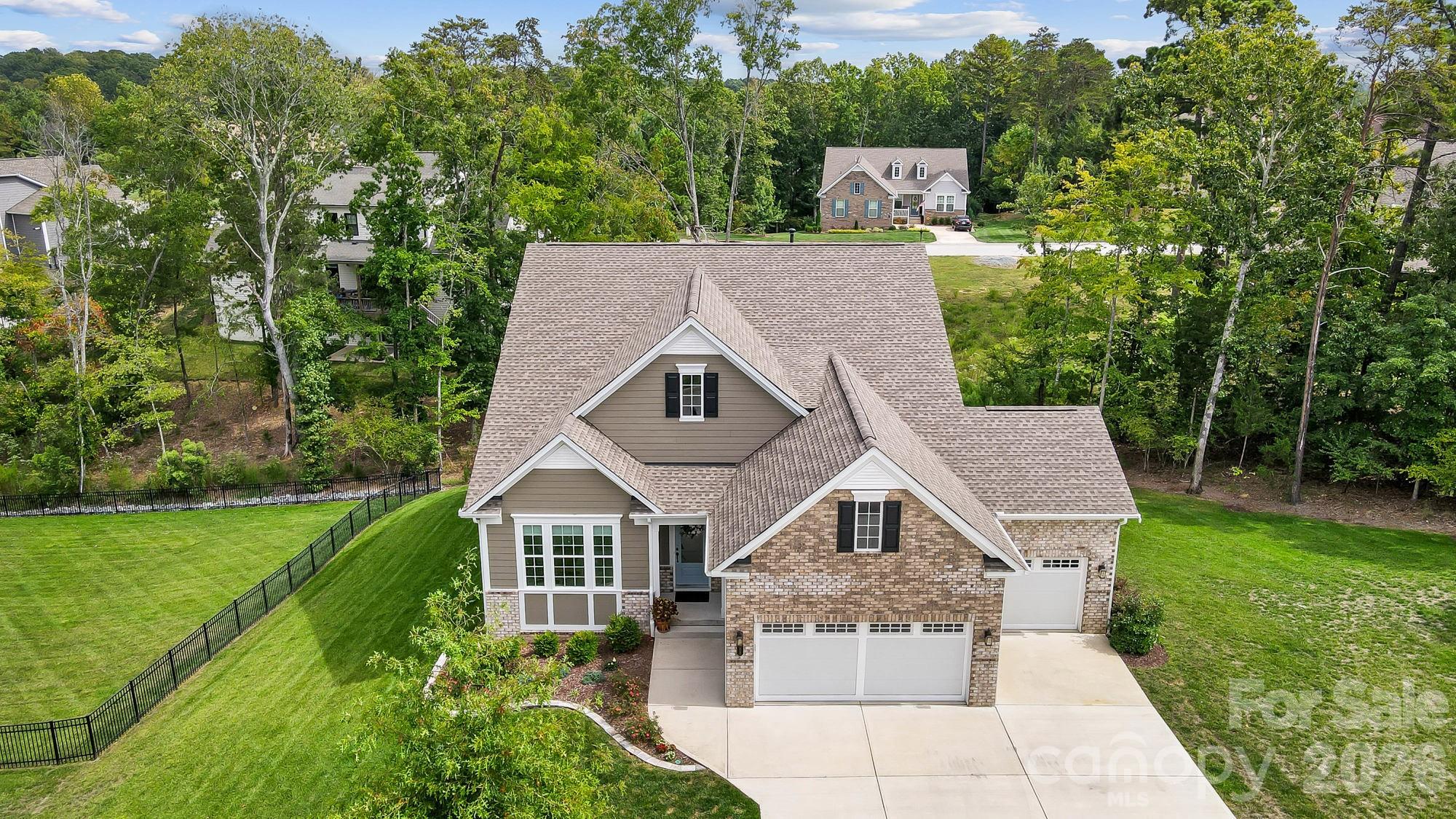 Welcome to Your Dream Home nestled in the prestigious gated community of Handsmill! This stunning property offers the perfect balance of luxury, privacy, and relaxed living. Enjoy the best of Lake Wylie with exclusive community amenities, low South Carolina taxes, and the award-winning Clover Schools. Located less than 5 miles from Lake Wylie’s new High School and Elementary (opening 2026–2027), and just 10 miles from Field Day Park and the Lake Wylie Aquatic Center. Inside, elegant design meets everyday comfort with high ceilings, expansive windows, and premium finishes throughout. The primary suite is conveniently located on the main level, accompanied by two additional bedrooms, one of which is currently used as an office. The chef’s kitchen is the centerpiece, featuring a spacious granite island with seating that opens up to the dining and living area, which offers a cozy fireplace. Step outside to the screened-in porch and upper deck, where you can enjoy taking in gorgeous sunrises to start your day and then finish your day by grilling out with family and friends.
The fully finished basement expands your lifestyle options, offering potential for second-living quarters with a spacious bedroom, full bath, living room, kitchenette with oversized island, theater/bonus room, and even a small workshop area. Outdoors, enjoy a covered patio overlooking the private backyard. Additional highlights include a three-car garage with epoxy-finished floors and a recently installed 24 kW whole-house generator for added peace of mind.
Residents of Handsmill enjoy resort-style amenities, including a clubhouse, pool, fitness center, sidewalks, and well-lit streets that foster a safe and welcoming environment. With easy commutes to Uptown Charlotte, Charlotte Douglas International Airport, multiple hospitals, restaurants, shopping, and endless opportunities for watersports on Lake Wylie—this home truly offers it all. Don’t miss the chance to own a move-in-ready home with thoughtful updates in one of Lake Wylie’s most desirable communities.