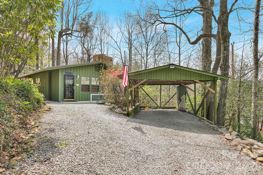 This inviting mountain cottage at 218 Hickory Lane offers a comfortable blend of charm and practicality, ideal for year-round living or a relaxing weekend getaway. Filled with natural light, the home features two bedrooms and two full baths, including a nicely updated bathroom with a classic clawfoot tub. The kitchen is efficient and functional, opening to a cozy dining nook and a comfortable living area with a new propane fireplace. Large windows throughout bring in plenty of light, creating a bright and welcoming feel even on cloudy days. A wraparound porch extends the living space outdoors, offering a great spot for grilling, dining, or simply enjoying the peaceful setting. There’s also a fire pit for cool evenings and gathering with friends and family. In the winter months, you’ll enjoy seasonal mountain views. Tucked away, this home offers a quiet, private feel while still being within close proximity of Pisgah, Dupont, and Brevard. A gated driveway and single carport add even more functionality. This is a great option for anyone looking to enjoy the simplicity and beauty of mountain living in Lake Toxaway, NC.