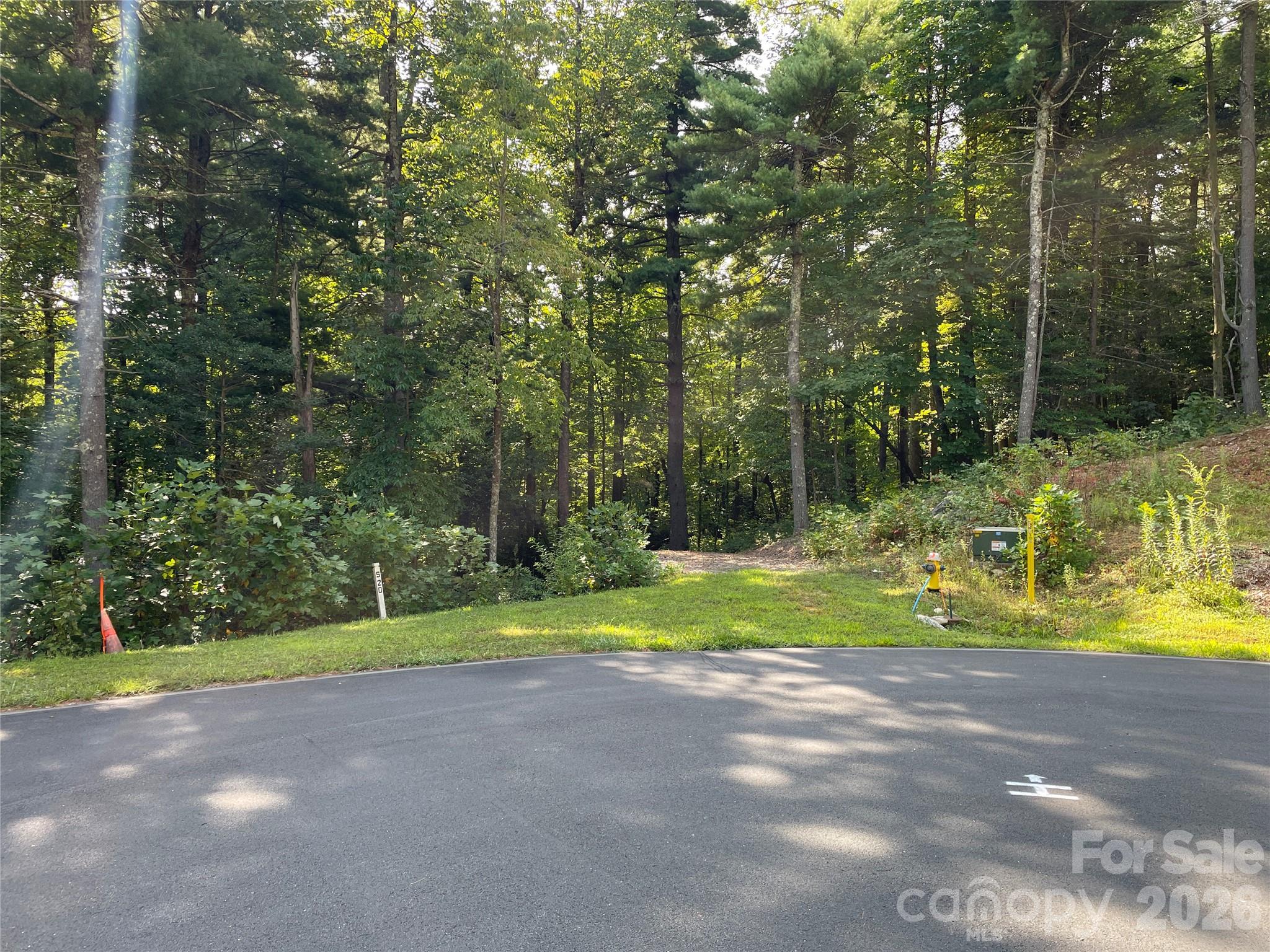 Take advantage of one of the few remaining "builder-friendly" lots in Kenmure. This property provides exceptional value for your dream home project, boasting a flat approach on a tranquil dead-end street. Surrounding this lot are stunning high-end homes with impeccable architecture and design, ensuring a neighborhood of quality and distinction. The gently sloping lot presents endless possibilities for flexible home design allowing you to create the perfect layout. Immerse yourself in the natural beauty of this lot, adorned with mature hardwood trees and a captivating mountain stream below the homesite's building site. This 1.64 acre nearly-level homesite is located just minutes from the clubhouse, fitness center, swimming pools, 18-hole golf course, tennis, and pickleball courts. 

Easy build lot with city water, natural gas and 1-gigabyte AT&T fiber network access for 
internet/telecommunications. 

Lot to be recorded at closing, part of parent parcel PIN #  9566-60-7878
