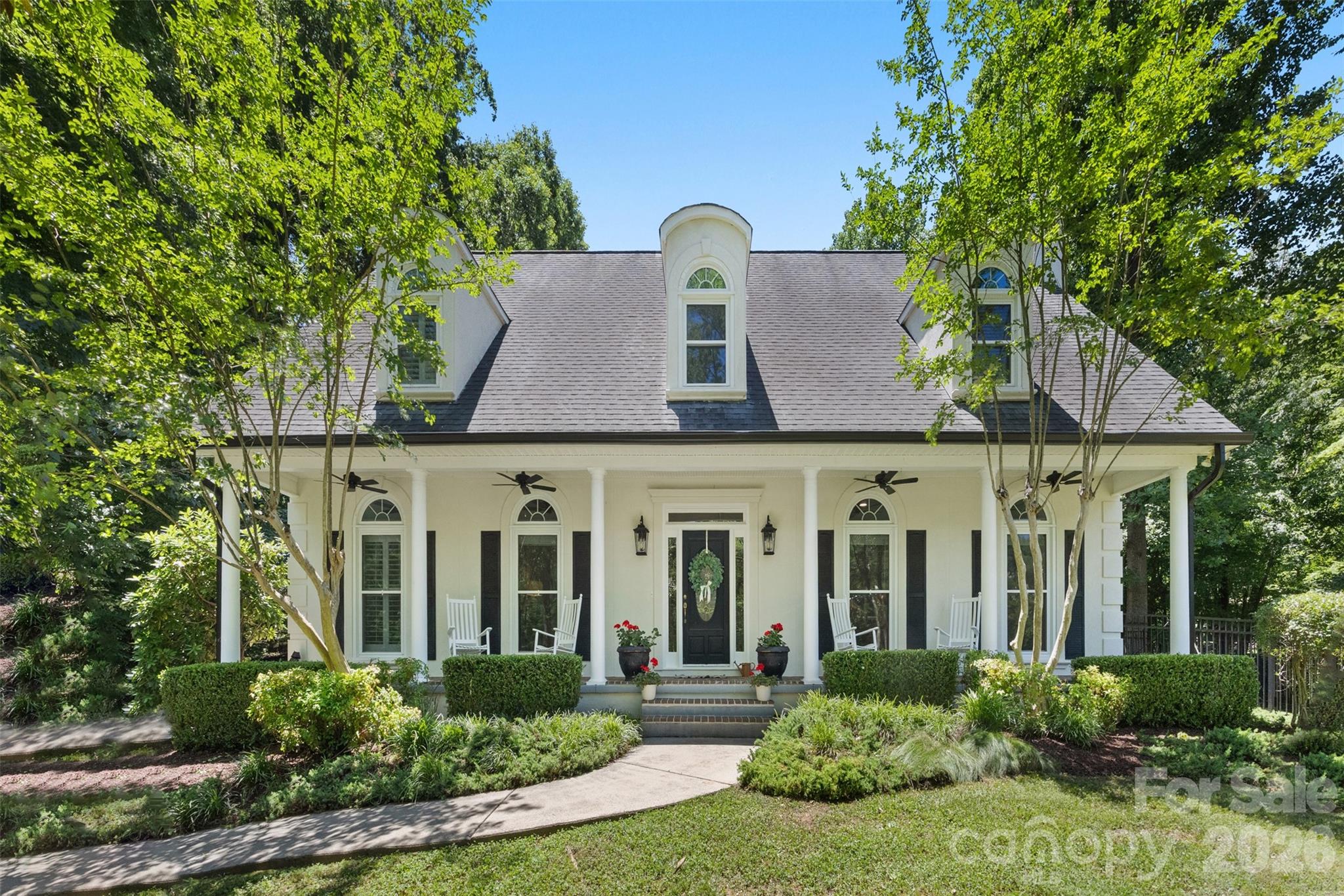 Rare opportunity to own an extensively updated home built on one of the most enchanting properties in all of the highly sought after Cramer Mountain Club, gated community. The home sits on top of a double tiered corner lot with an abundance of room for your family and pets to play. Three outdoor living spaces include a front porch with ceiling fans, a natural tree canopy covered back patio, and a moss covered side yard with a boulder strewn active creek. Enjoy your morning coffee listening to a gentle water cascade or host an evening dinner party under the bistro lights criss crossing the creek. Entering the home you will immediately notice a blend of timeless & modern upgrades as well as flexibly designed spaces throughout. A pantry separating the kitchen from the great room was removed and replaced with a burly cabinet from a Pennsylvania farm in the late 1800s. This small change created a flexible great room/sunroom with an abundance of natural light and a view of the creek. Unique features include a vintage Italian olive basket light fixture, a whimsical powder room door, an old oak church door in the lower primary suite, and a sliding barn door leading to the luxurious bathroom of the second floor bedroom suite. Both potential primary suites have uniquely striking light fixtures, soaking tubs, and a water closet. The third full bathroom has its own statement making marble tile flooring and unique lighting. 
Other functional features of the home include all new exterior windows with protective screens, new garage doors, plantation shutters in the bedrooms, custom closets, mudroom/laundry room w/ utility sink, walk-in attic, gas log fireplaces, and an expansive bonus room/optional fifth bedroom above the great room. Come check out resort style living at it’s finest in a mountain community conveniently located only 10mi from the airport and 18 mi from downtown Charlotte! The property comes with a social club membership which includes full access to the pool, tennis, pickleball, playground, partial golf, and near daily social events. All you need is a golf cart to get from one activity to the next! Reach out today for a feature sheet and schedule a showing today while there is still time.