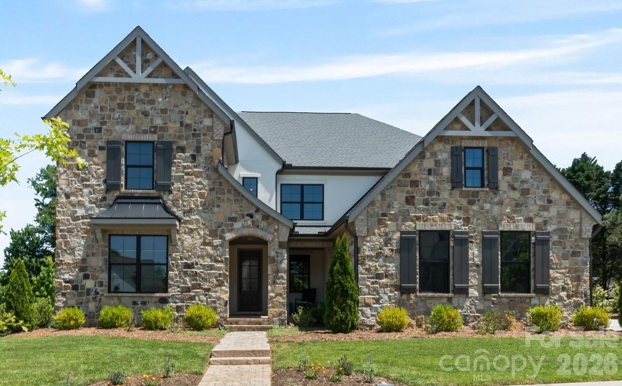 This Classica home, built in 2022, is situated on one of the most desirable lots in Oak Farm. Featuring a premium stone façade, surrounded by HOA-owned land and mature trees, and showcasing countless high-end upgrades throughout, this property is truly a must-see. Step inside to discover a main-level primary suite featuring a tray ceiling, cozy sitting area, and a spa-inspired ensuite bath. The bathroom offers a walk-in shower with dual shower heads, a standalone soaking tub, dual vanities, and a spacious walk-in closet with direct access to a laundry room. The main level also offers two versatile flex spaces, ideal for a home office, gym, media room, or additional living area. Custom steel and glass doors elevate these spaces and create a stunning focal point. The chef’s kitchen is equipped with top-of-the-line Wolf appliances, including a 48-inch range and additional wall oven, along with quartz countertops, two dishwashers, a beverage refrigerator, a scullery with sink, and a walk-in pantry. The kitchen flows into both the dining area and the expansive living room, which features custom built-ins, a gas fireplace, integrated sound system, and access to the screened porch. Designed for year-round enjoyment, the screened porch includes retractable screens, a gas fireplace, and the perfect indoor/outdoor living experience. Upstairs, a loft offers additional entertaining space with a wet bar, beverage refrigerator, and sitting area. The upper level also includes two guest suites with ensuite baths, plus two additional bedrooms connected by a Jack-and-Jill bath with double vanity and tub/shower combo. A second laundry room completes the upper level. Outside, enjoy a fully fenced backyard with a raised garden bed and native blackberries that bloom during the summer months. The three-car garage is pre-wired with a 50-amp electrical charging system for Level 2 EV charging. Additional highlights include interior wall insulation, an ADT pre-wired security system and a whole-house surge protector. Residents enjoy community amenities including a playground and firepit. Conveniently located near Northstone Country Club (~2 miles), Birkdale Village (~3 miles), and Lake Norman (~5 miles), this home offers luxury living in an unbeatable location.