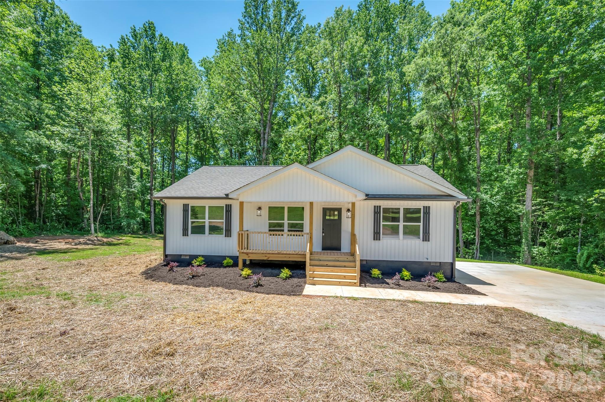 Brand new construction on 1.08 acres just minutes from downtown Forest City! This beautiful 3 bedroom, 2 full bath home offers a desirable split-bedroom floor plan designed for both comfort and privacy. The primary suite features an ensuite bath with a double vanity and a spacious walk-in closet. Enjoy relaxing mornings on the covered front porch or unwind on the back deck overlooking the peaceful stream that runs along the back side of the property. With modern finishes, a functional layout, and a convenient location less than 5 minutes from downtown Forest City, this home offers the perfect blend of country charm and everyday convenience!