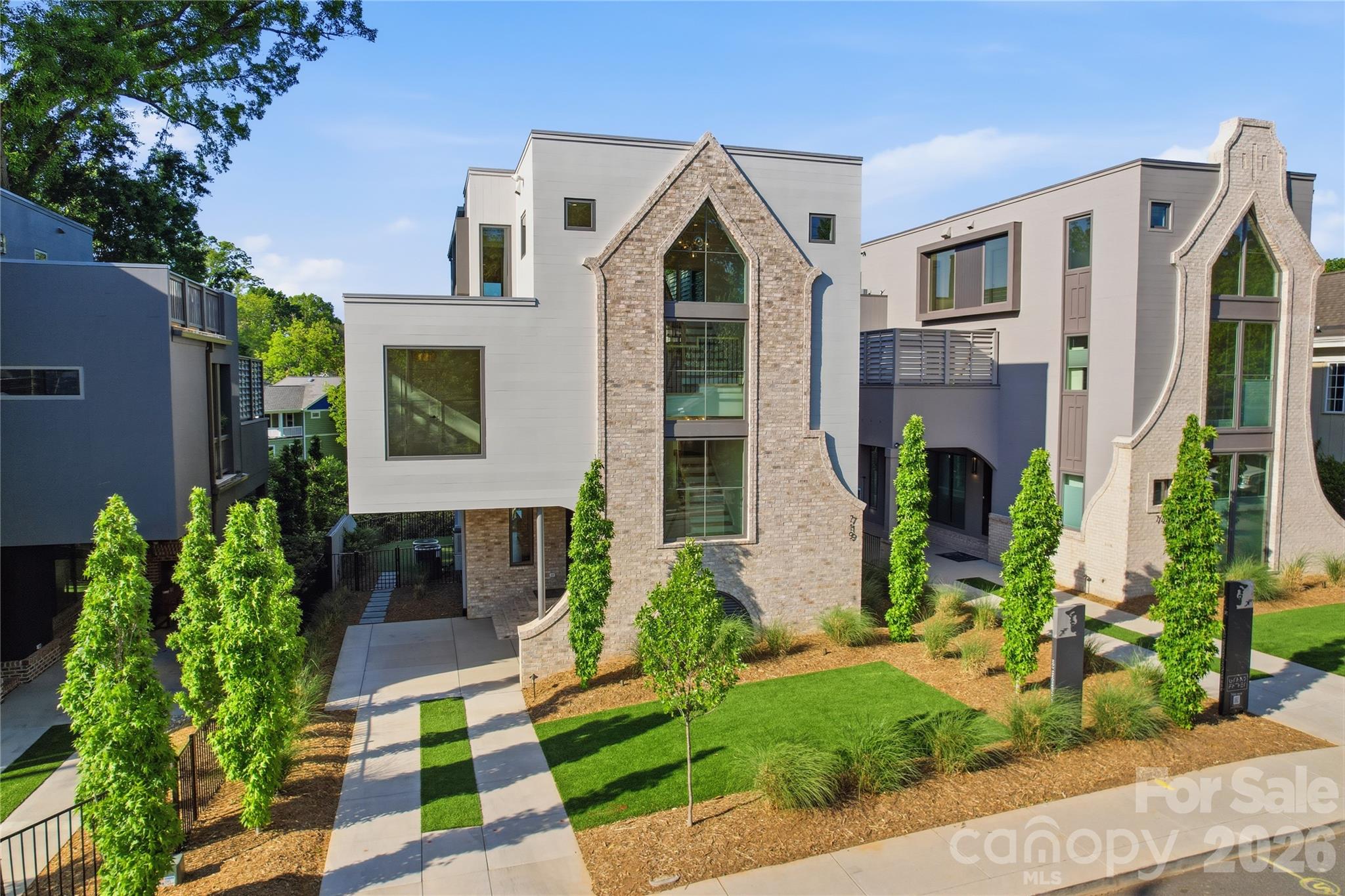 Crafted through a visionary partnership between Grandfather Homes and Elite Design Group, this 5-bed / 5-bath custom residence offers elevated living in Heirloom at Mattie Rose. Main floor features an open-concept layout with dining and great room sliding doors opening to covered terrace with fireplace. Chef’s kitchen showcases Thermador appliances, large island, plus walk-in scullery. Main level office or bedroom with full bathroom. Primary suite offers two generous walk-in closets and bathroom with soaking tub, tile shower, and dual vanities. Third floor is an entertainer’s dream with rooftop terrace and cocktail pool, media room with wet bar, and full guest suite. Low-maintenance artificial turf in the front and rear yards. This artfully curated village of just nine custom homes combines luxury and sustainability in the heart of NoDa, offering walkable access to dining, nightlife, and culture. Come experience "art-itecture"—where every detail is designed to elevate your lifestyle.
