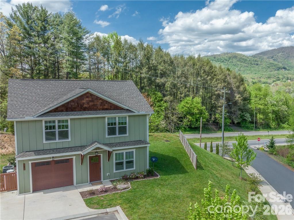 Picturesque energy-efficient home in convenient pocket neighborhood with long range views and easy access to nearby mountain towns, and just a 27 minute drive to Downtown Asheville. Thirteen recently constructed GREEN homes sit perched above the Clyde community a 7 minute drive to Waynesville and Lake Junaluska, with far east-facing views and easy access to all WNC has to offer, situated in the geographic midpoint of Western North Carolina's best small mountain towns. This home lives large, with an open concept great room leading to updated kitchen and office nook, with garage for storage or workshop space. Primary bedroom suite is expansive, with soaking tub and generous walk-in closet. Upstairs laundry closet with ample room for guests, home gym or office uses. Natural gas services major home systems, and energy-saving features from advanced insulation to EnergyStar appliances help keep your costs and your carbon footprint modest. Enjoy full time as the sellers have, or use as turn-key second home with a view, or reliable investment property in the ideal location.
