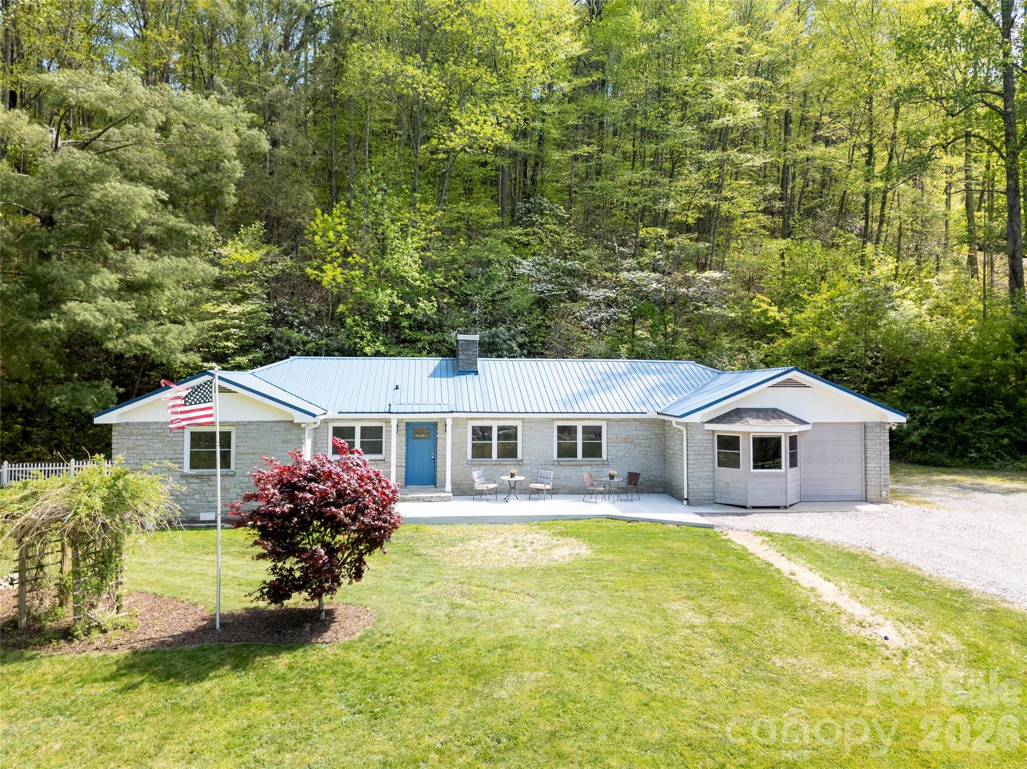 RARE RESIDENTIAL/COMMERCIAL OPPORTUNITY IN THE HEART OF MAGGIE VALLEY.  Set on a level .92-acre lot with a distinctive granite stone exterior, this spacious ranch with basement offers the comfort of a well-appointed residence paired with the flexibility of C-1 zoning, allowing residential and/or commercial use. Previously used as both an insurance office and real estate office, the property is ideal for a buyer who wants room to live, work, store equipment, park trailers, or create a highly flexible basecamp in the mountains. Potential uses may include office, contractor or landscape business, vacation rental concept, motorcycle-friendly lodging, or other approved C-1 uses.

The main level features approximately 2,460 heated square feet with 4 bedrooms and 3 full baths, gleaming wood floors, a split-bedroom layout, spacious living and dining areas, and a remodeled kitchen with walk-in pantry. The generous primary suite includes a lounge area, expansive walk-in closet with built-ins, whirlpool tub area, roll-in tiled shower, large vanity area, and additional built-in storage.

The basement offers approximately 1,340 additional square feet not counted in heated living area due to ceiling height, of 6’11 1/2” inches (less than 1/2 inch of required height)  but it is heated and cooled and offers exceptional versatility with a separate exterior entrance, second kitchen, full bath, laundry closet, stained concrete floor, and space for recreation, storage, workshop, office, or guest overflow. Laundry is available on both the main level and basement level.
Recent improvements include interior paint, refinished living room floor, updated lighting, new front concrete patio, new gravel drive, new vapor barrier, exterior pressure washing, roof pressure washing, new chimney cover, new front gutter, and more. With city water/sewer, easy Soco Road access, generous parking, and room for trailers, RVs, boats, or equipment, this property offers a rare blend of mountain character, practical utility, and investment flexibility.