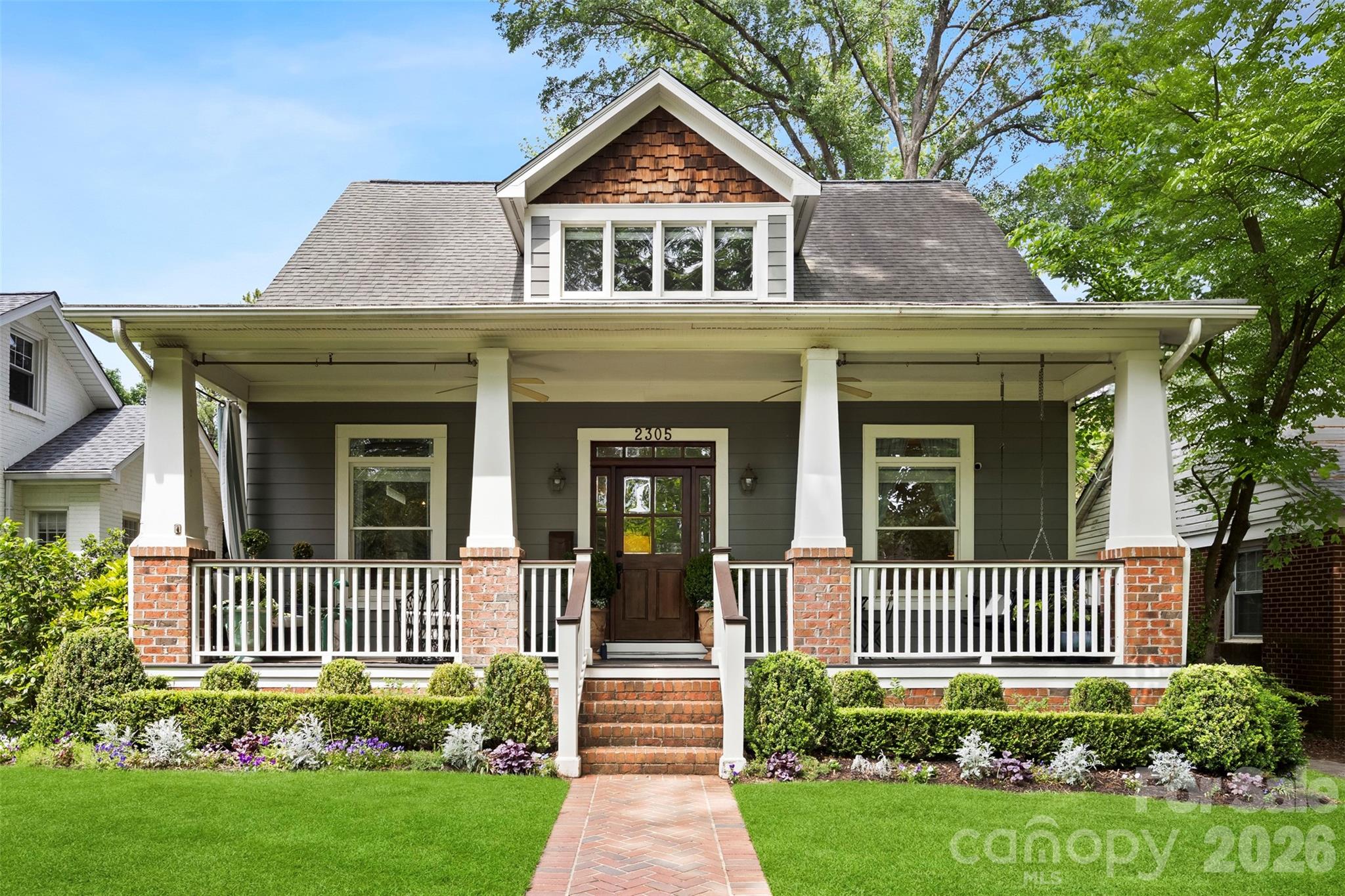 Beautifully renovated and full of charm, welcome to 2305 Shenandoah Avenue, an exceptional Craftsman residence nestled in the heart of highly sought after Chantilly on one of the neighborhood’s most charming tree-lined streets. Blending timeless architecture with thoughtfully curated modern updates, this beautifully designed home offers refined finishes, functional living spaces, and designer-inspired touches throughout.

A large, inviting front porch welcomes you into the light-filled interior featuring 10- and 11-foot ceilings on the main level, refinished hardwood floors, extensive millwork, and a striking coffered ceiling in the great room. The versatile floor plan offers multiple living and entertaining spaces designed for both everyday comfort and elevated hosting, including gas fireplaces in both the living room and family room that create warm and inviting gathering spaces throughout the home.

A standout 2024/2025 architectural renovation transformed a former two-story open area into two beautifully functional levels, creating an expansive family room on the main floor complete with a custom lacquered built-in bar and hidden storage, while the upper level provides the perfect flex space for a playroom, media room, office, or additional lounge area. A whole house audio system further enhances the home’s seamless entertaining experience.

The gourmet kitchen serves as the centerpiece of the home, showcasing stunning White Rhino marble countertops, designer unlacquered brass hardware, a large center island with abundant prep and gathering space, stainless steel appliances, gas range, walk-in pantry, and seamless flow into the dining and living spaces, as well as a three-season EZE-Breeze porch with cedar lining and updated tile flooring. Every detail has been thoughtfully considered, from designer lighting and curated wallpaper selections to freshly painted interiors that highlight the home’s incredible natural light.

Upstairs, the privately tucked-away vaulted primary suite offers a serene retreat with sophisticated finishes, dual custom cedar closets, and a spacious feel. Two additional bedrooms and a versatile flex space with custom built-in cabinetry and office space complete the upper level. Additional highlights include a main-level guest bedroom with an updated bath, three separate living spaces, a butler’s pantry/storage closet off the dining room, and hidden under-stair storage ideal for coats and small appliances.

Outdoor living is equally impressive with custom landscaping and a private rear yard designed for year-round enjoyment, entertaining, and relaxation. Alley access and a detached two-car garage provide additional functionality and storage opportunities. The home also enjoys access to the beloved side street, often used by neighbors for bike riding, pickleball, and community gatherings. Located on the neighborhood Halloween parade route which is Chantilly's biggest event and has been going on for 26 years! 

Located just minutes from Uptown Charlotte, neighborhood parks, dining, shopping, and entertainment, this exceptional Chantilly home offers the perfect balance of historic Craftsman charm, elevated design, and modern livability.