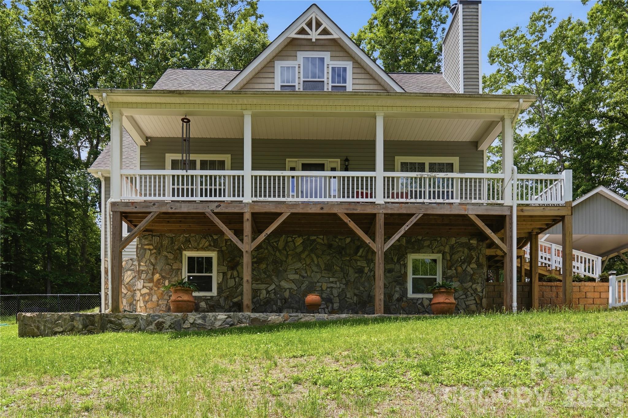 PRICE IMPROVEMENT! Welcome to this charming modern farmhouse retreat on 10+ private acres, offering the perfect blend of rustic charm and contemporary comfort. Just a quick 30 minute drive from the Charlotte airport you'll find picturesque, mountain-like view from this rocking chair front porch, and a spacious covered rear deck where you can relax and unwind.

The open-concept main level features hardwood floors and a wood-burning fireplace, creating a warm and inviting atmosphere. The light-filled kitchen showcases custom cabinetry, ample storage, and generous counter space—ideal for cooking and entertaining.

The main-level primary suite includes a private en suite with an over-sized soaking tub, separate over-sized shower, private water closet, dual sinks, and a spacious vanity.  A large walk-in closet provides abundant storage for your wardrobe. Upstairs, two generously sized bedrooms and a full bath provide flexible space for a home office or growing family.

The partially finished basement is waiting for your personal touch. It offers endless potential with a chimney for future wood-stove installation, and plumbing in place for future design. A separate exterior entrance makes this space perfect for so many possibilities including a guest suite, entertainment area, or a home gym. 

Outside, a custom designed covered carport complements the home and protects your vehicles from the elements. A personal storage building is conveniently located for your tools and equipment. There is a fenced area in the back yard for your pets to enjoy. Mature fruit-bearing trees for your pleasure include 2 pear and 1 plum. There is also a fig bush. 

The wired, lighted workshop has a concrete floor and includes an automotive lift that awaits your next project or hobby, perfect for DIY enthusiasts or anyone needing extra space for their crafts or work. A small barn with a fenced pasture adds character and function to the property. A serene creek runs through the middle of the home-site just beyond the workshop and barn. You will cross over it as you drive up to the home.

With ample space for outdoor activities, gardening, or even livestock, this property offers endless possibilities. Whether you're looking for a quiet country escape, a hobby farm, or simply a peaceful retreat to call home, this property is the perfect place for rural living with modern style.