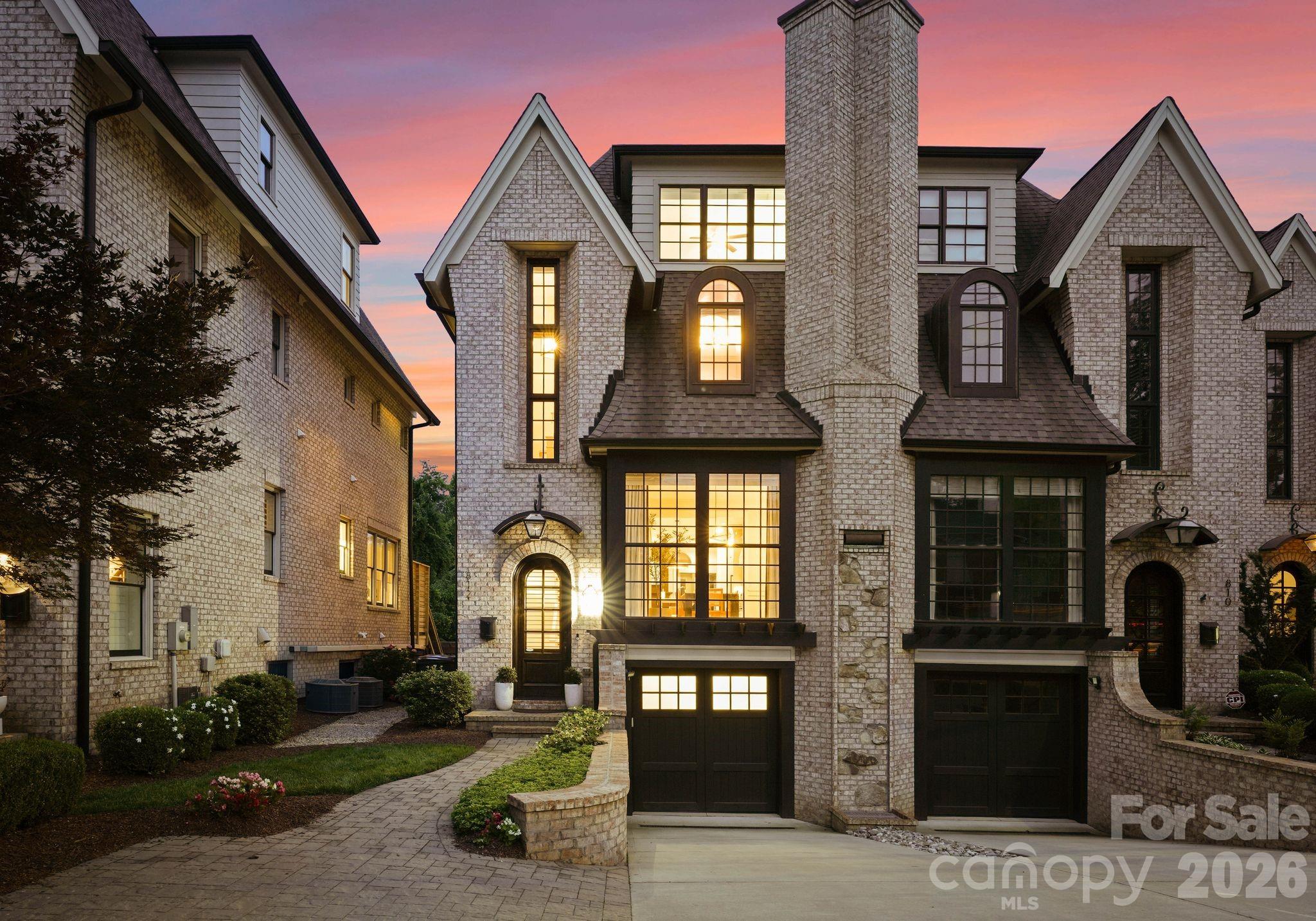 Perfectly positioned in the heart of Dilworth, this stunning four-story luxury townhome delivers an exceptional blend of sophisticated design, high-end finishes, and effortless urban living within minutes of South End, Uptown, and SouthPark.

Thoughtfully designed from the ground up, the main level features 10-foot ceilings, an open-concept layout, and a chef's kitchen appointed with Thermador professional appliances, custom floor-to-ceiling cabinetry, a walk-in pantry, and a statement island with seating for three. The formal dining room features a gas fireplace, designer light fixtures, and wainscoting, while the living room centers on a gas fireplace and opens directly to the upper-level patio, complete with a Weber grill, a lounge area, and an outdoor fan. A well-appointed half bathroom with accent wallpaper completes the main floor.

The second level is anchored by a sprawling primary suite with a 14-foot vaulted ceiling, exposed wood beams, oversized windows, and dual walk-in closets with custom shelving, drawers, and clothing racks. The spa-inspired primary bathroom features a freestanding soaking tub, dual vanity, private water closet, and a walk-in shower with multiple fixtures and a shaving mirror. A generous guest bedroom with a private en suite bath, dedicated laundry room, and multiple storage closets round out this level.

The third level offers incredible flexibility, with a lounge area perfect for a media room, office, or entertaining space, alongside a second guest bedroom with its own en suite bath and shower/tub combination.

The lower level is equally impressive, featuring a spacious living area with a wet bar, wine and beverage refrigerator, and cabinetry storage, plus a half bathroom, a built-in drop zone with bench, cubbies, and shelving, and a two-car tandem garage with epoxy flooring and storage shelving. 

Outside, the home truly shines. The lower-level covered patio is an entertainer's dream, sheltered by motorized retractable screens and outfitted with an outdoor lounge area and a ceiling fan, creating a seamless indoor-outdoor living experience year-round. Step beyond the covered patio into a backyard designed for both relaxation and entertaining, where a spa, gas fireplace, and manicured turf area invite you to unwind, and a stone patio provides the perfect setting for al fresco gatherings. Professional landscaping frames every inch of the outdoor space, delivering privacy and curb appeal in equal measure.

Four stories of luxury amenities, a private outdoor sanctuary, and one of Charlotte's most sought-after zip codes. A combination this rare doesn't last long!