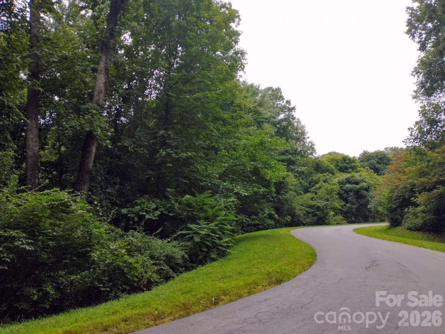 Build your amazing home nestled in the forest of the high-end gated community of Versant in North Asheville! At 2.34 acres, this is the largest lot to be listed for sale in the last five years, with a site for a home by the road near the top of the property and no possibility for homes on the other side of the street.  It is perhaps the quietest lot anywhere near Asheville -- you have to hear it to believe it! Versant includes public underground utilities (city water, electric, natural gas, public sewer and high-speed internet), privately maintained roads and walking trails. Conveniently located close to I-26 and only minutes to downtown Asheville or the charm of Weaverville. Geotechnical engineering analysis is already complete and an architect-designed construction example is shown in the photos. Buy now to get your future home started today!