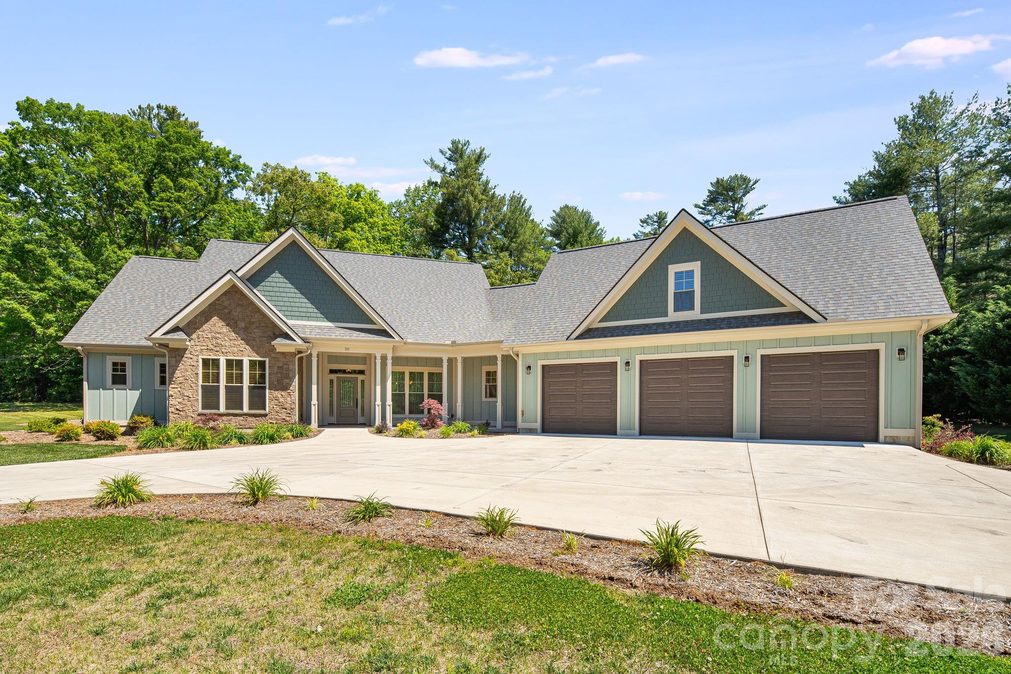 Welcome to luxury living in desirable Berwick Downs. Situated on a beautifully landscaped 0.75-acre lot, this exceptional custom-built home offers 5 bedrooms, 4 full baths, and 3,340 square feet of thoughtfully designed living space. From the moment you arrive, the circular concrete driveway and stunning curb appeal set the tone for the quality and craftsmanship found throughout. Inside you'll find wide plank Hickory hardwood flooring, vaulted and tray ceilings, custom built-ins, quartz countertops, and a spacious open-concept layout designed for both everyday living and entertaining. The living room features a cozy gas log fireplace and flows seamlessly into the chef's kitchen complete with KitchenAid appliances, an island, and generous prep space with two sinks. The private primary suite offers a true retreat with a spa-inspired bath featuring a spacious soaking tub, tiled walk-in shower, and walk-in closet. There are three additional bedrooms on the main level and two full baths. Upstairs, there is an oversized bedroom that provides a flexible space for guests, a home office, media room, or multigenerational living with its own private full bath. Additional highlights include a 3-car garage, tankless water heater with recirculation system, generator hookup, covered front and rear porches, and premium finishes throughout. Residents also have the opportunity to enjoy neighboring Kenmure's golf, dining, social, and recreational amenities through optional membership access, with convenient golf path connectivity directly from Berwick Downs to the Kenmure Community. This custom home offers the perfect blend of elegance, comfort, lifestyle, and location in one of Flat Rock's most sought-after communities.